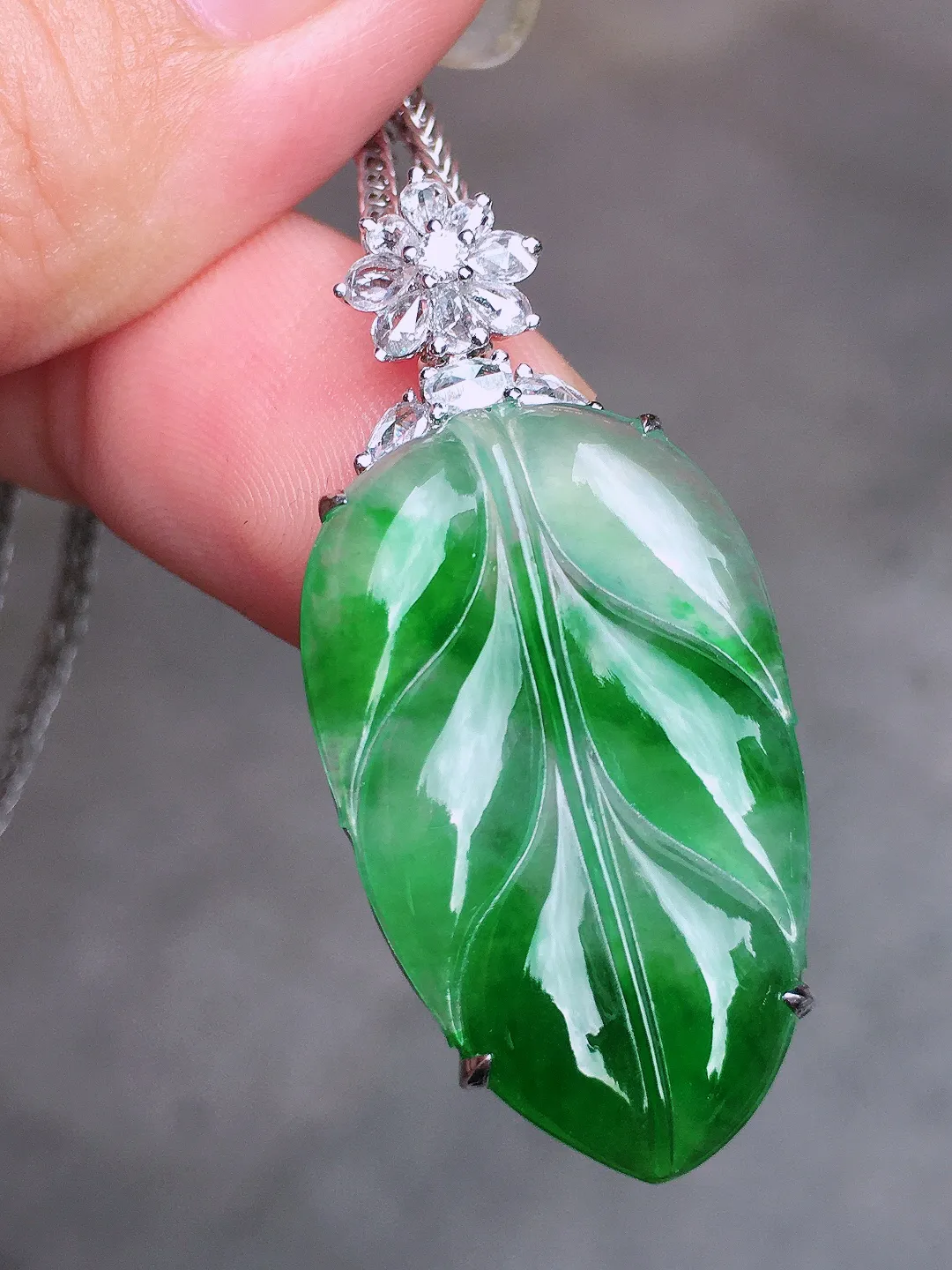 飘绿玉叶吊坠，色泽艳丽，玉质细腻，荧光感超
强，饱满圆润，气质满满。18k
金豪华镶嵌