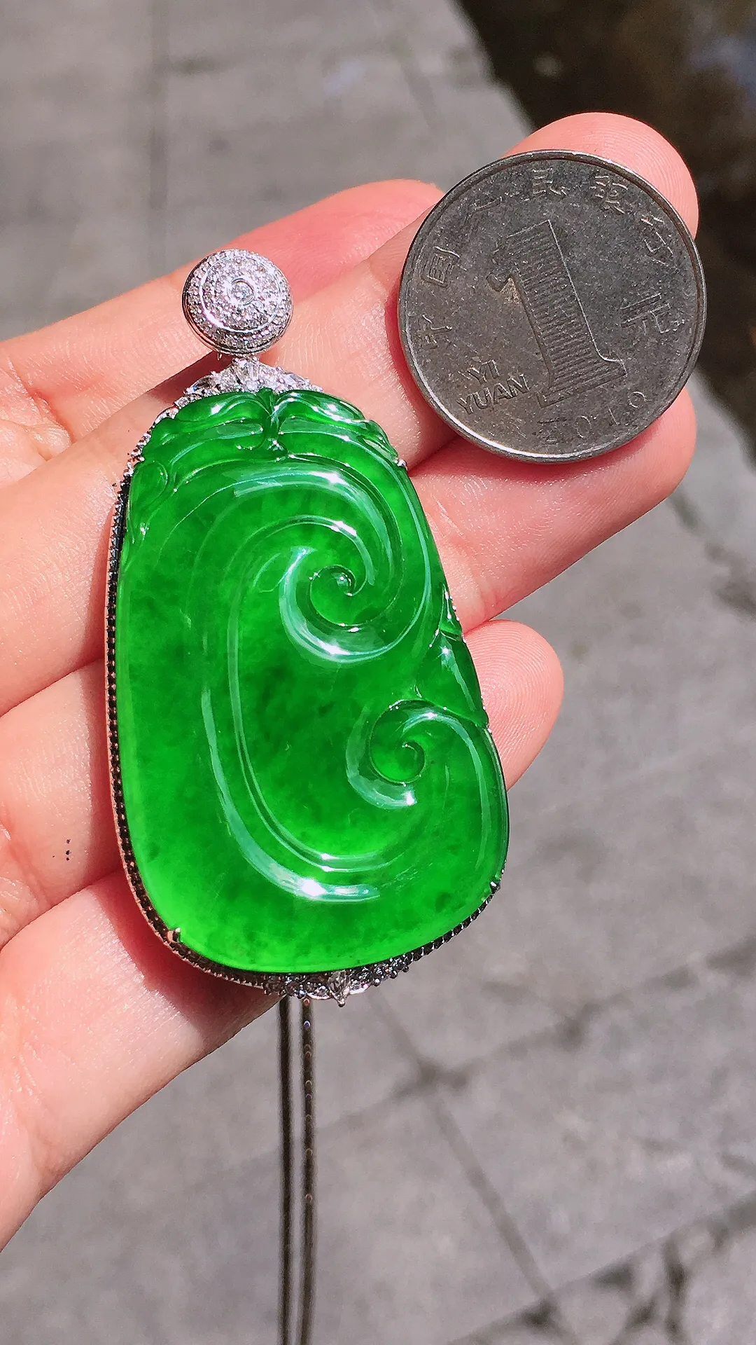 阳绿如意吊坠，色泽均匀艳丽，玉质细腻，荧光感超
强，饱满圆润，气质满满。18k
金豪华镶嵌