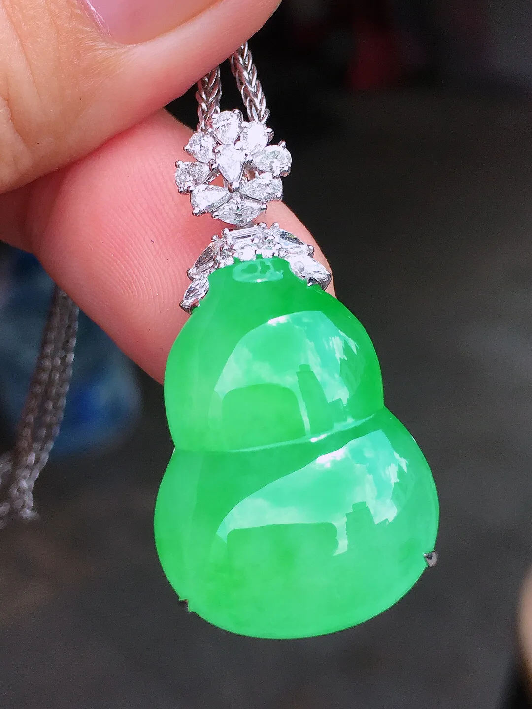阳绿葫芦吊坠，色泽均匀艳丽，玉质细腻，荧光感超
强，饱满圆润，气质满满。18k
金豪华镶嵌