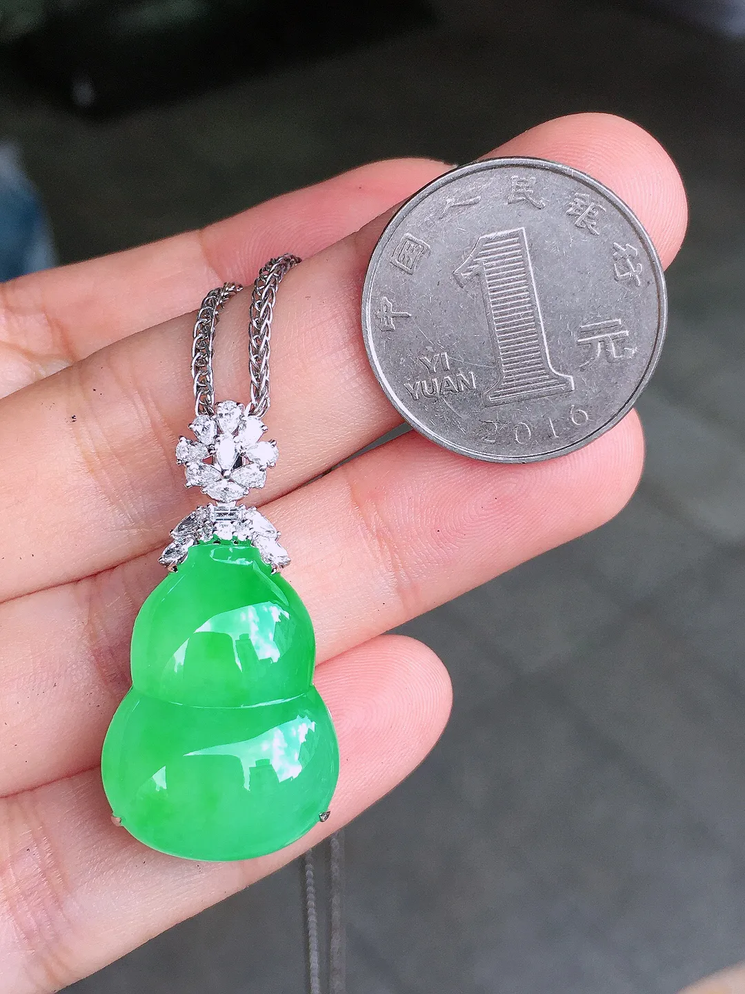 阳绿葫芦吊坠，色泽均匀艳丽，玉质细腻，荧光感超
强，饱满圆润，气质满满。18k
金豪华镶嵌