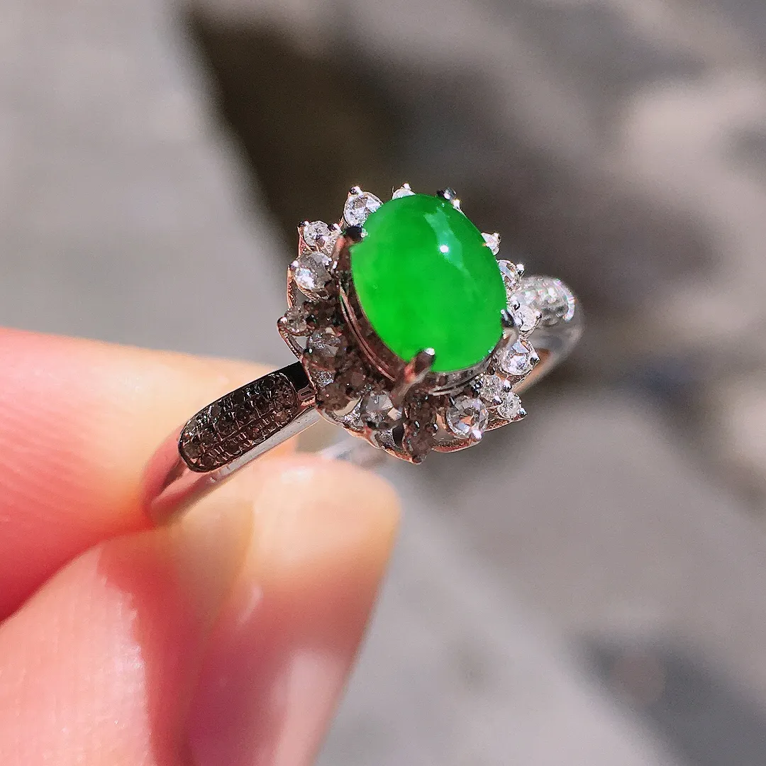 阳绿蛋面戒指，色泽均匀艳丽，玉质细腻，荧光感超
强，饱满圆润，气质满满。18k
金豪华镶嵌