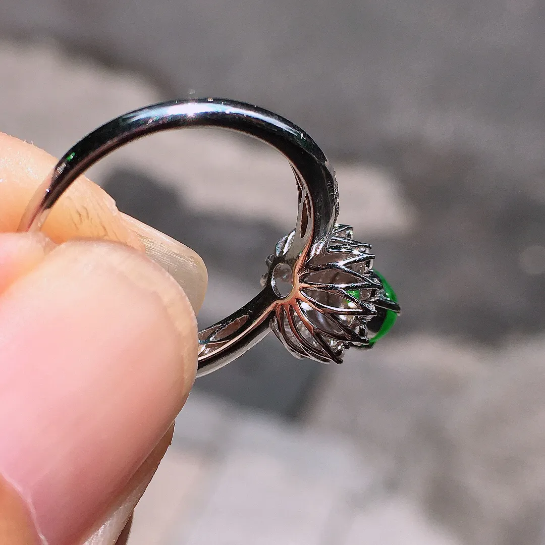 阳绿蛋面戒指，色泽均匀艳丽，玉质细腻，荧光感超
强，饱满圆润，气质满满。18k
金豪华镶嵌