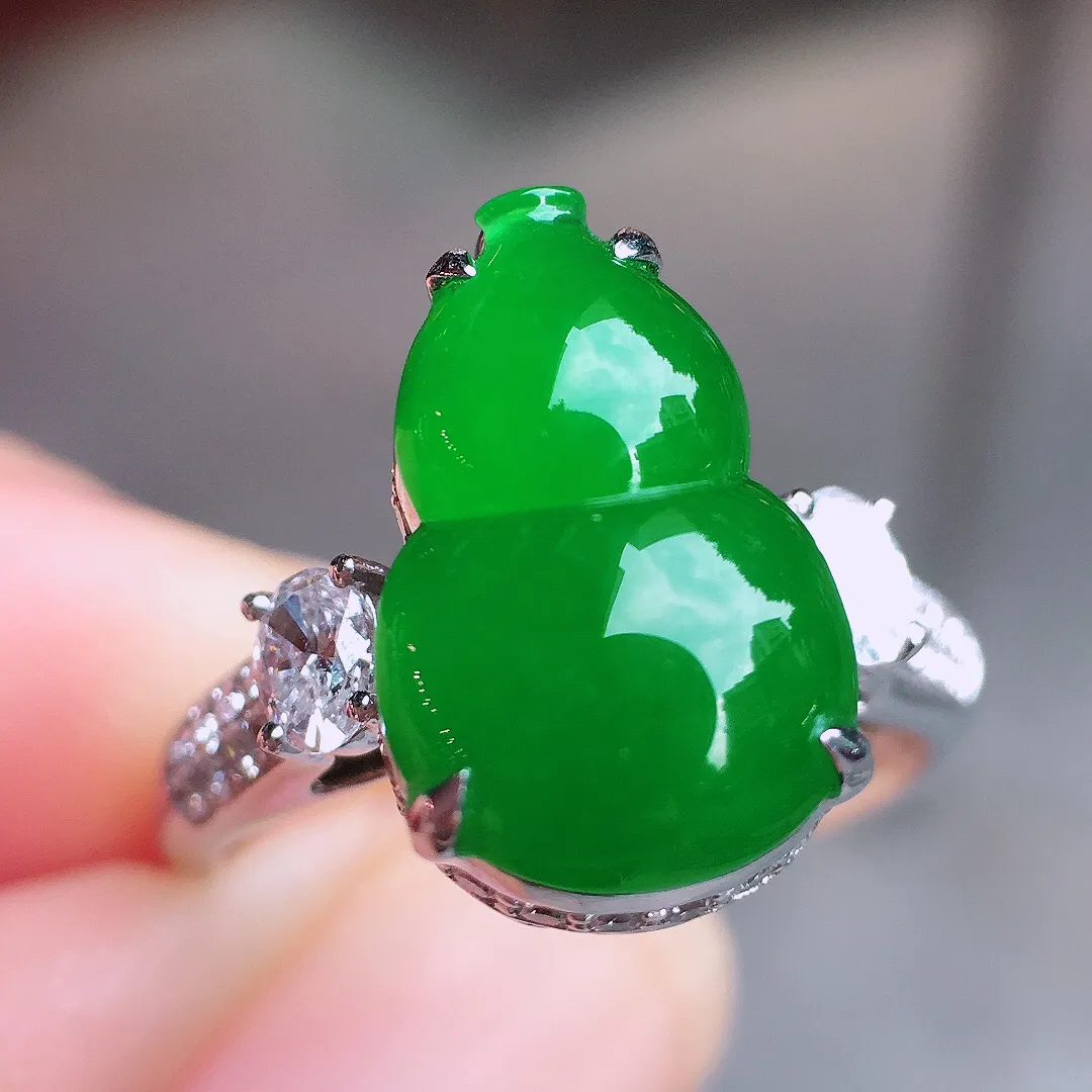 阳绿葫芦戒指，色泽均匀艳丽，玉质细腻，荧光感超
强，饱满圆润，气质满满。18k
金豪华镶嵌