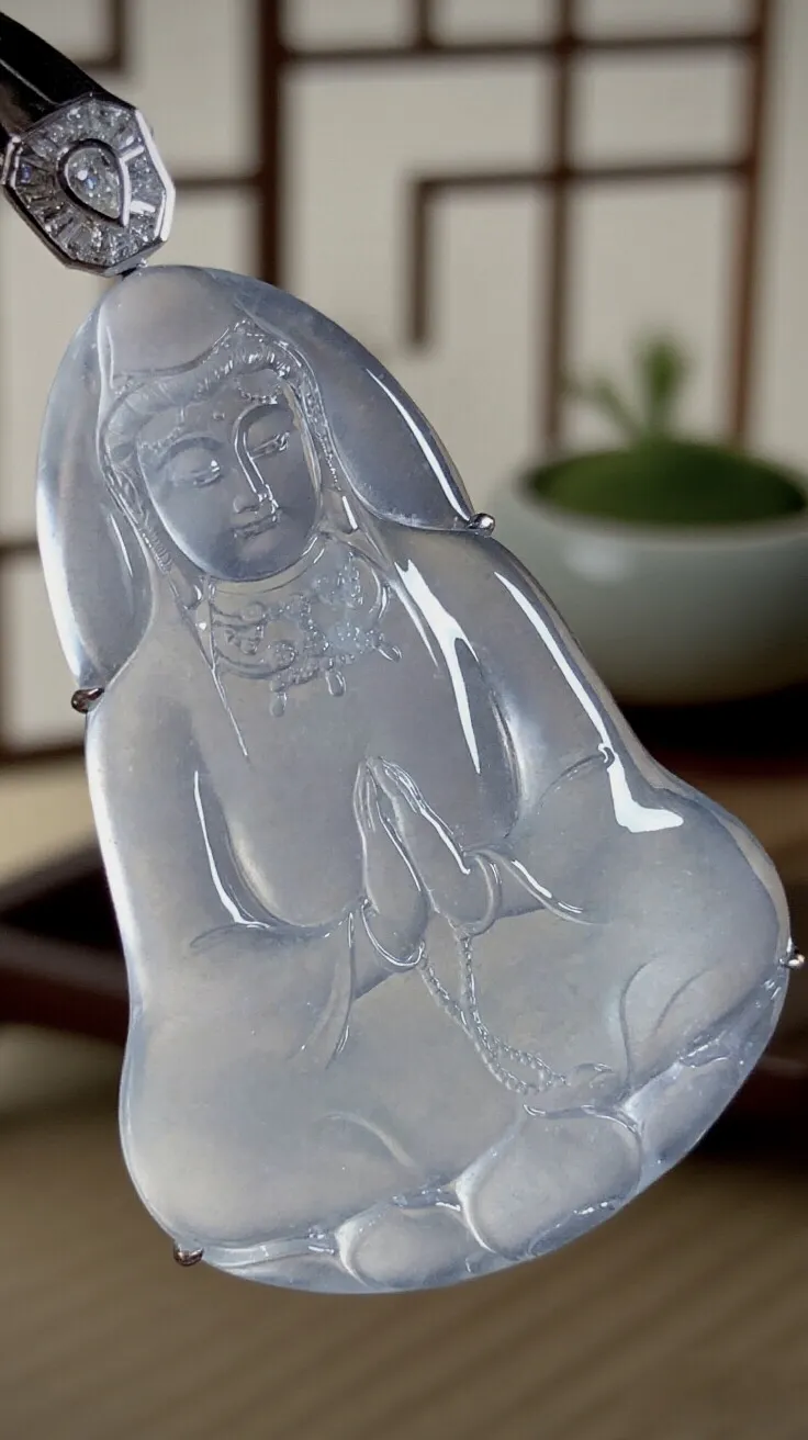 【慈悲为怀·观自在】，合十观音菩萨。
山海玉雕艺术作品，
纯白冰翡翠料子，大师雕刻，线条简约流畅，
开脸慈祥端庄，宁静温和。18K金，南非钻衬托。
作品裸石63-43-5.5mm，整体73-43-8mm。