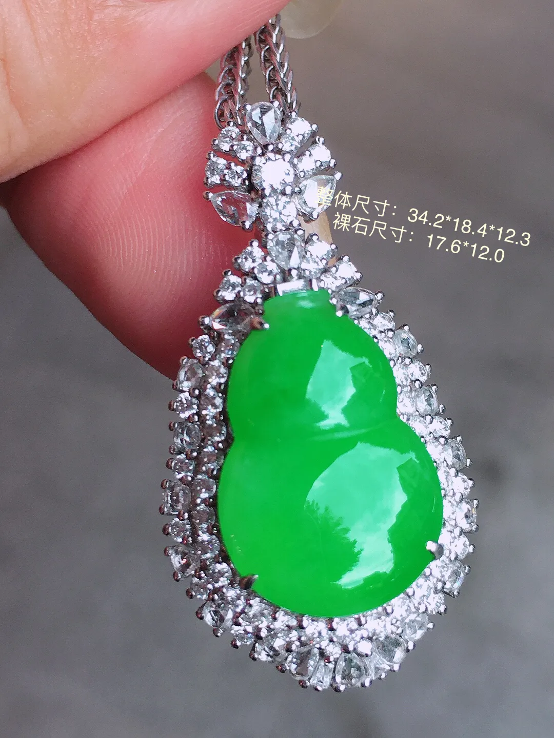 阳绿葫芦吊坠，色泽均匀艳丽，玉质细腻，荧光感超
强，饱满圆润，气质满满。18k
金豪华镶嵌