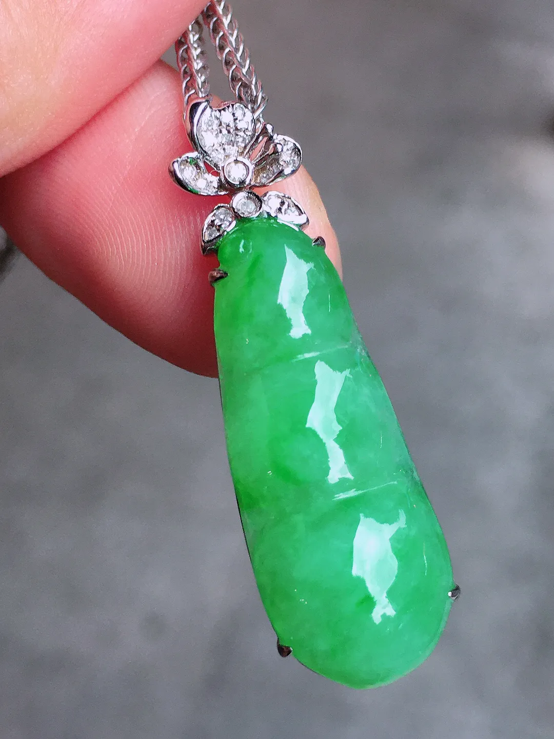 阳绿福豆吊坠，色泽均匀艳丽，玉质细腻，荧光感超
强，饱满圆润，气质满满。18k
金豪华镶嵌