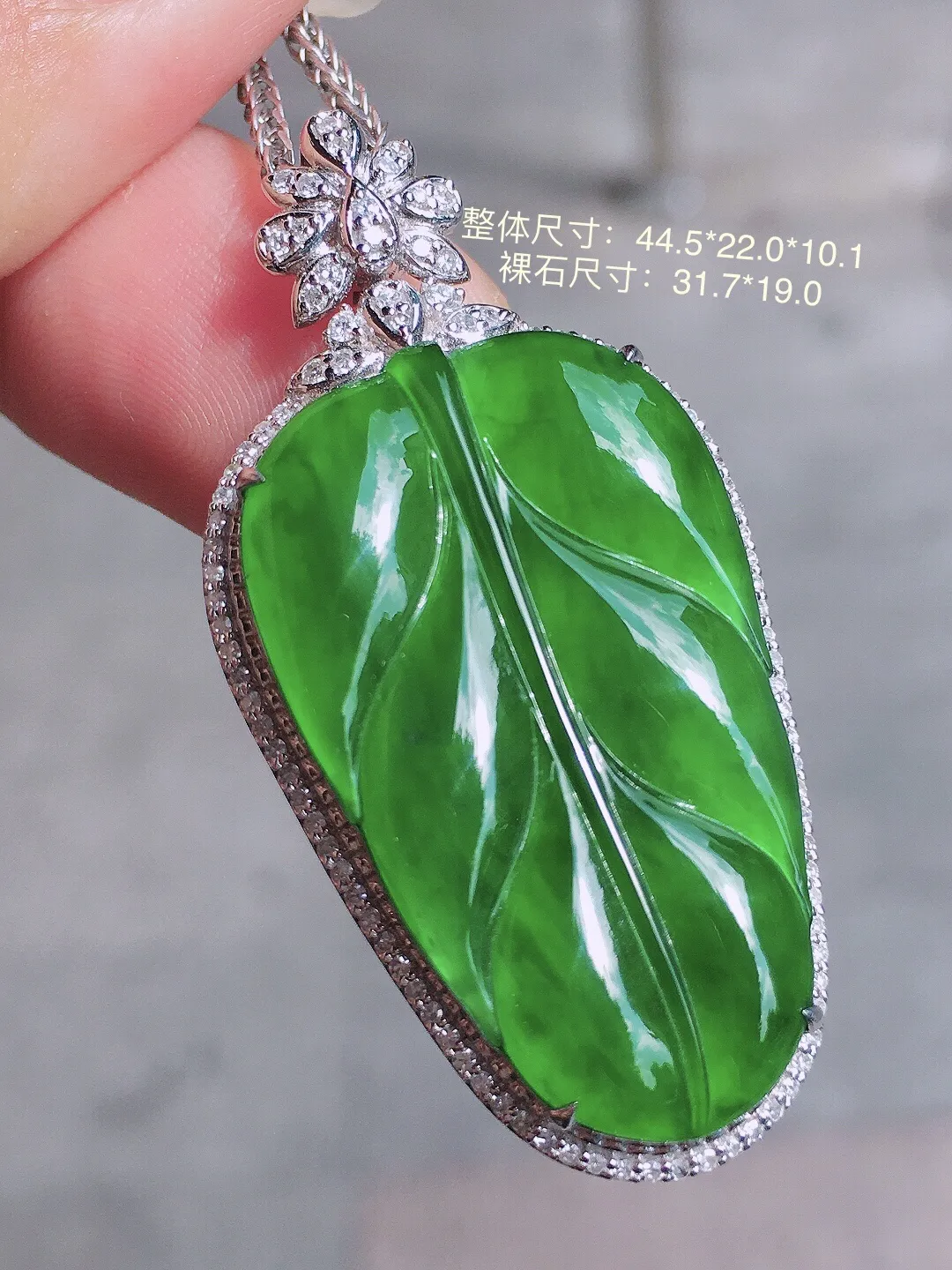 满绿玉叶吊坠，色泽均匀浓郁，玉质细腻，荧光感超
强，饱满圆润，气质满满。18k
金豪华镶嵌