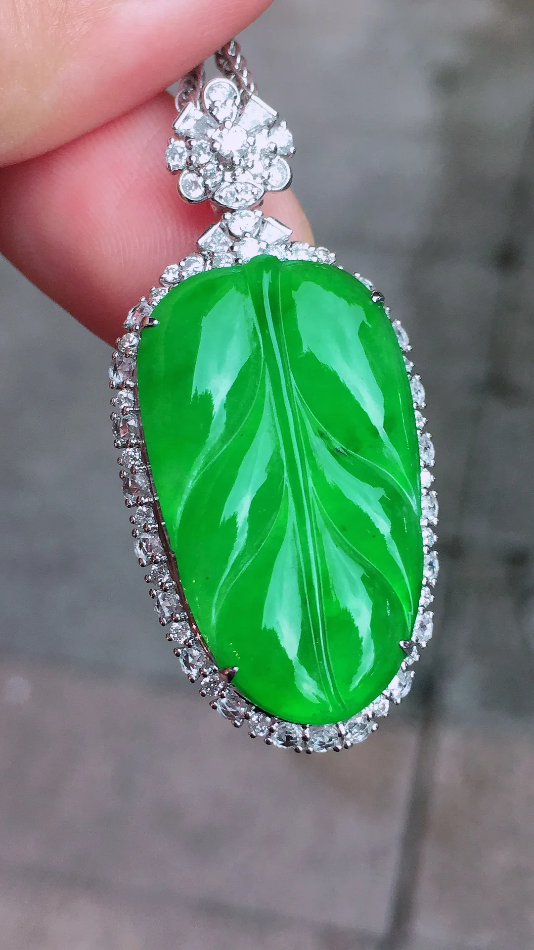 阳绿玉叶吊坠，色泽均匀艳丽，玉质细腻，荧光感超
强，饱满圆润，气质满满。18k
金豪华镶嵌