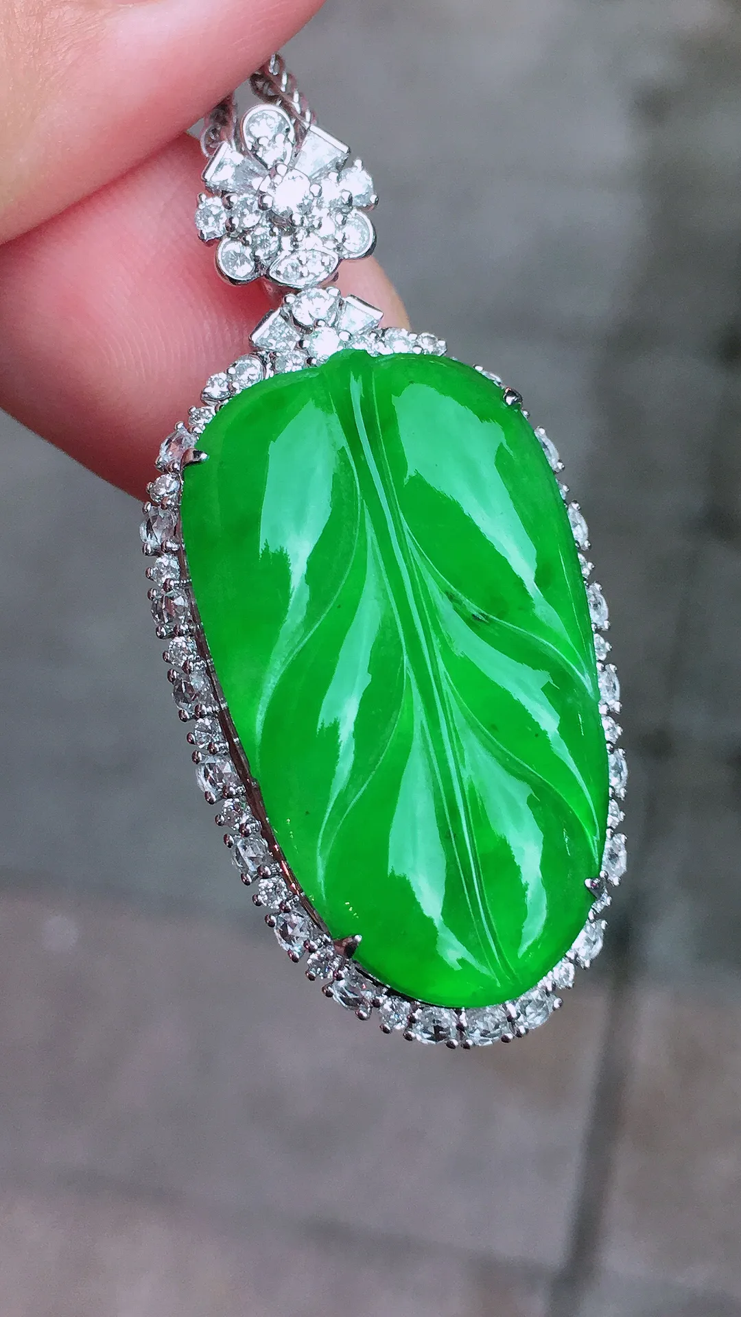 阳绿玉叶吊坠，色泽均匀艳丽，玉质细腻，荧光感超
强，饱满圆润，气质满满。18k
金豪华镶嵌