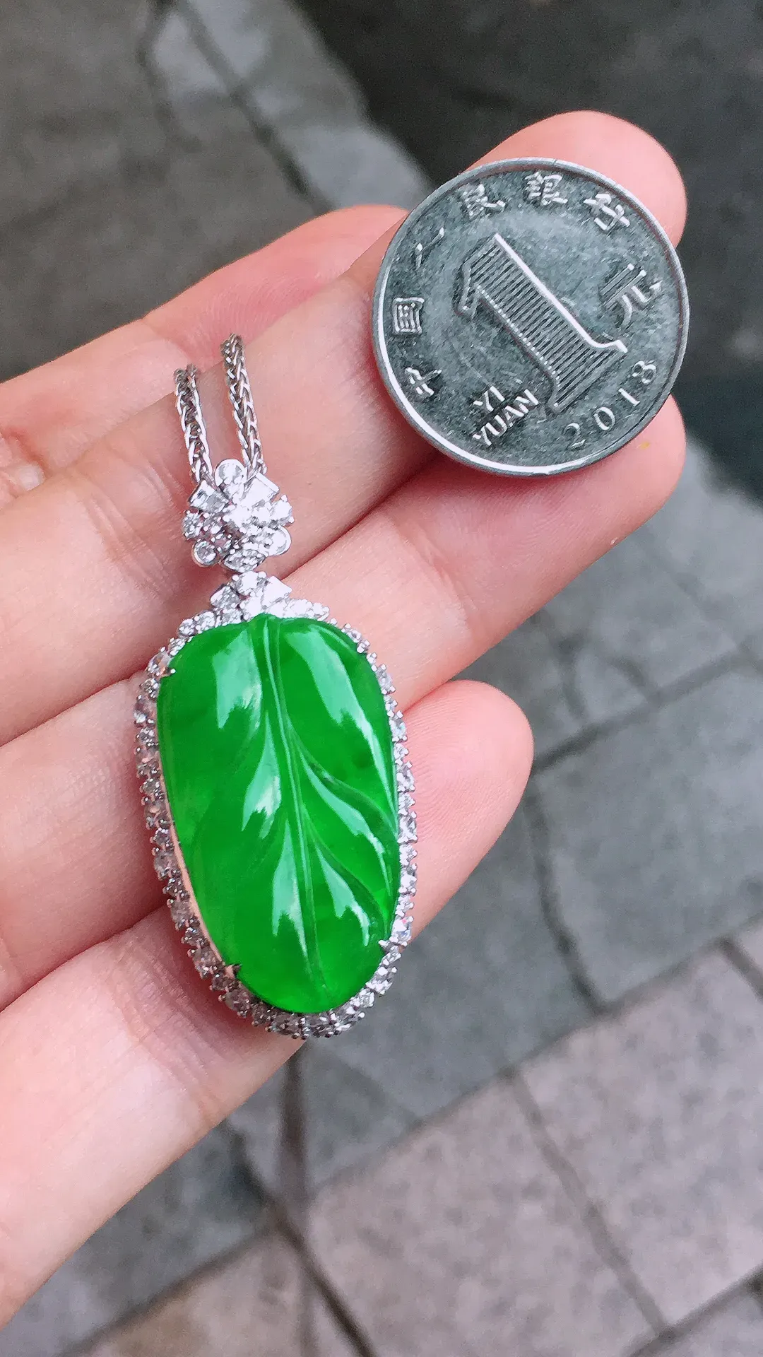 阳绿玉叶吊坠，色泽均匀艳丽，玉质细腻，荧光感超
强，饱满圆润，气质满满。18k
金豪华镶嵌