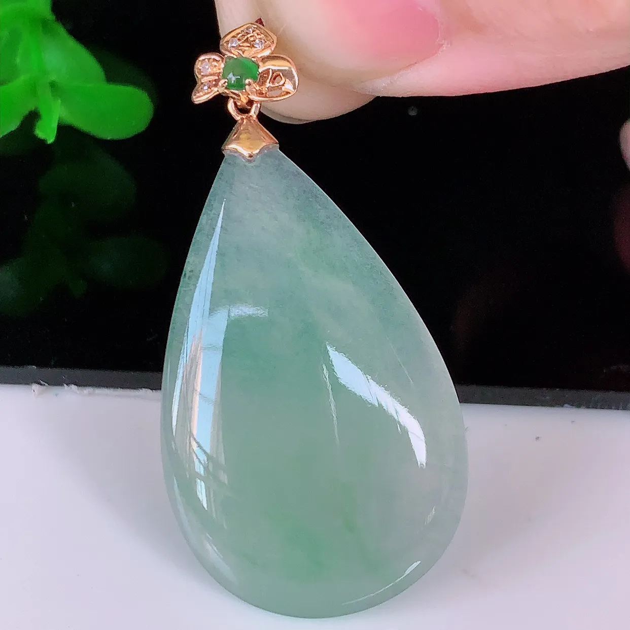 自然光实拍，18K金镶嵌冰种飘绿翡翠水滴吊坠，品相佳，颜色漂亮，佩戴时尚优雅，尽显气质。水滴寓意“水
