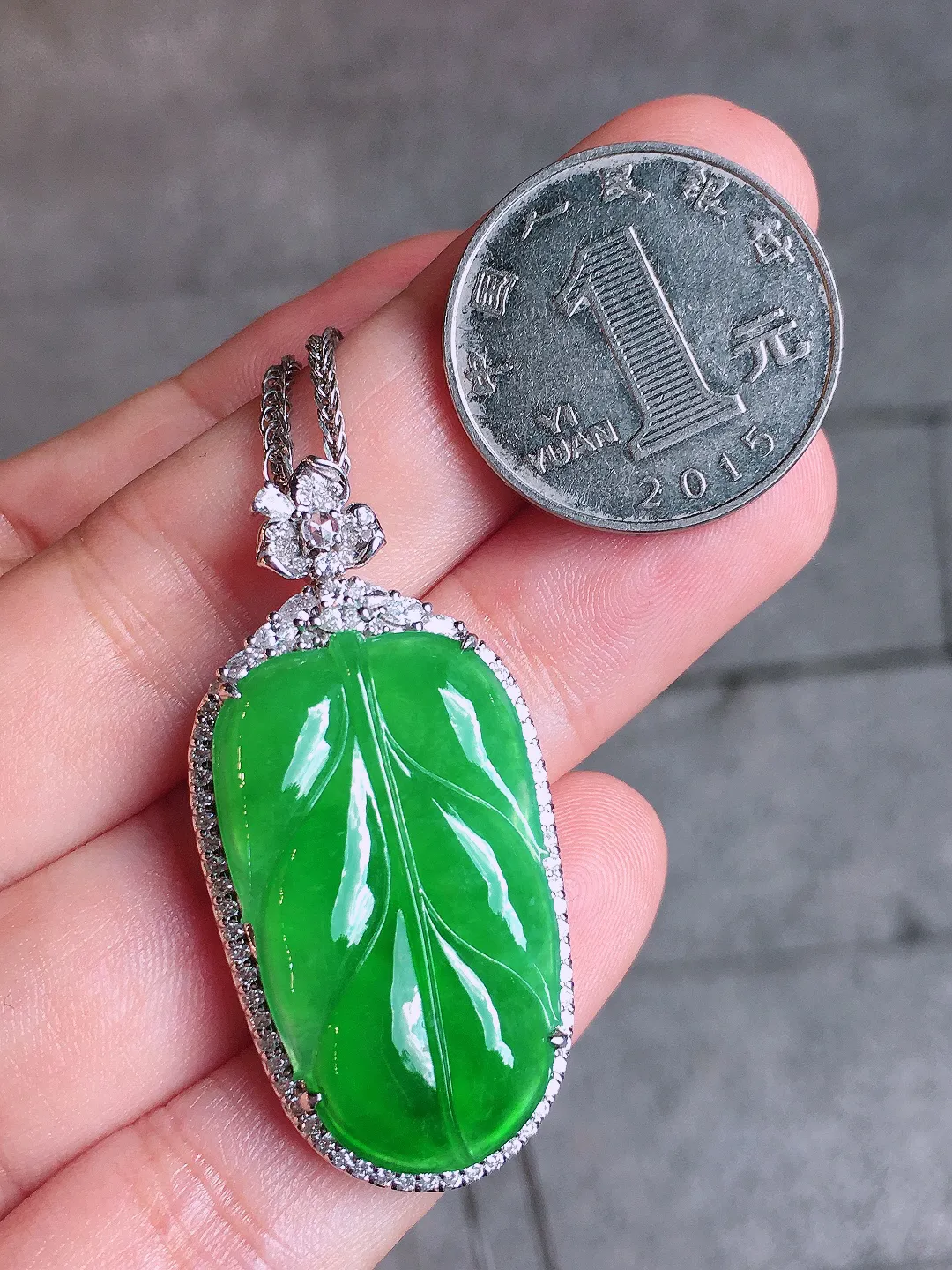 阳绿玉叶吊坠，色泽均匀艳丽，玉质细腻，荧光感超
强，饱满圆润，气质满满。18k
金豪华镶嵌