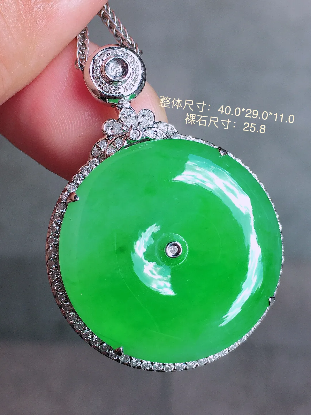 阳绿平安扣吊坠，色泽均匀艳丽，玉质细腻，荧光感超
强，饱满圆润，气质满满。18k
金豪华镶嵌