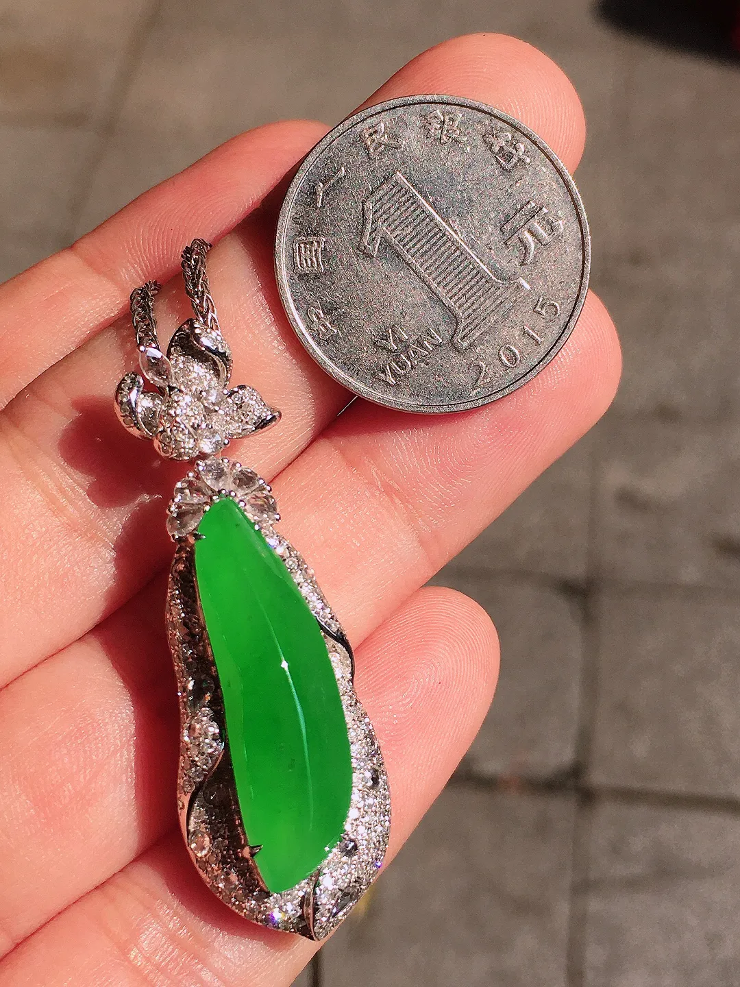 阳绿福瓜吊坠，色泽均匀艳丽，玉质细腻，荧光感超
强，饱满圆润，气质满满。18k
金豪华镶嵌