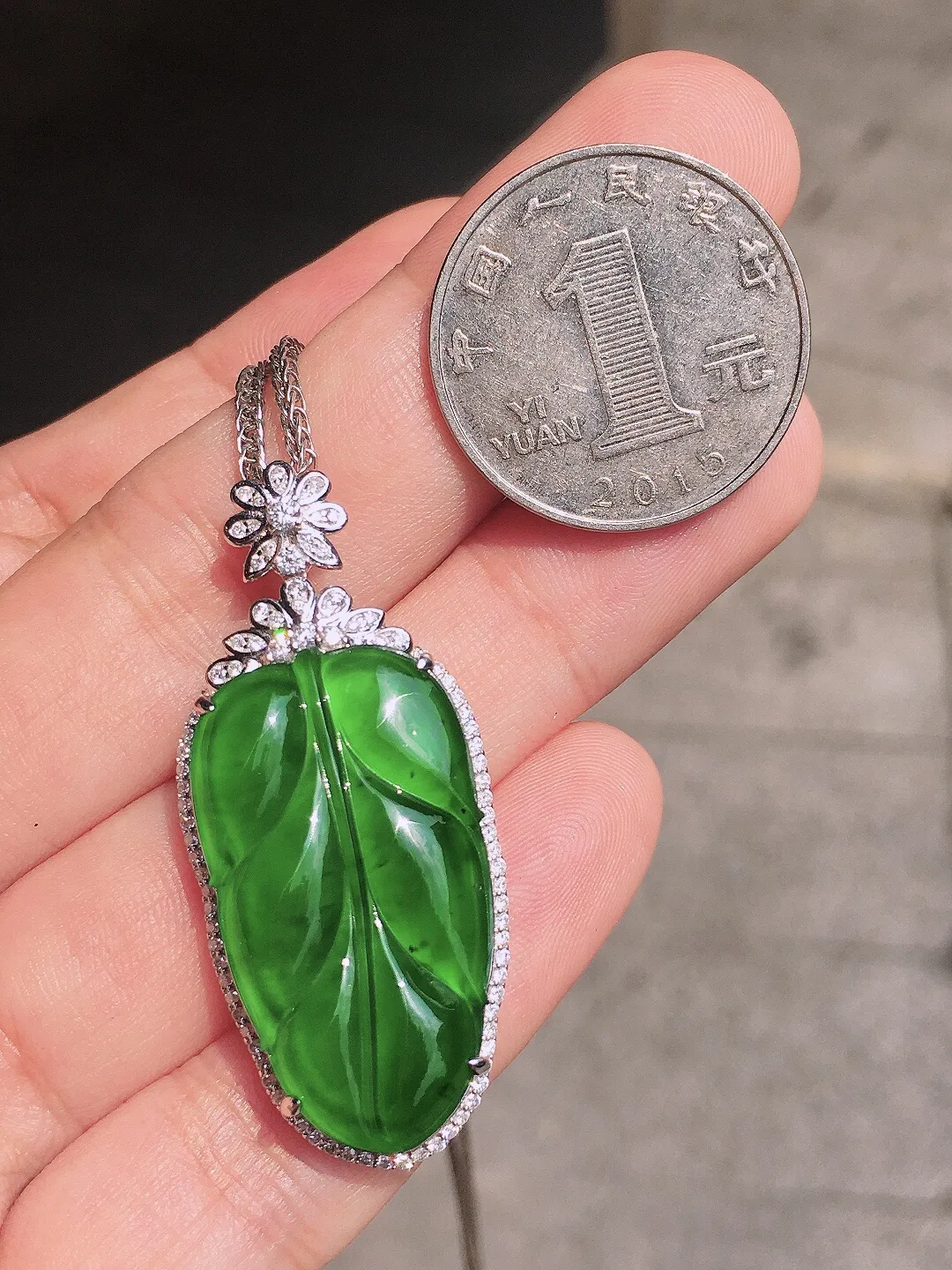满绿玉叶吊坠，色泽均匀浓郁，玉质细腻，荧光感超
强，饱满圆润，气质满满。18k
金豪华镶嵌