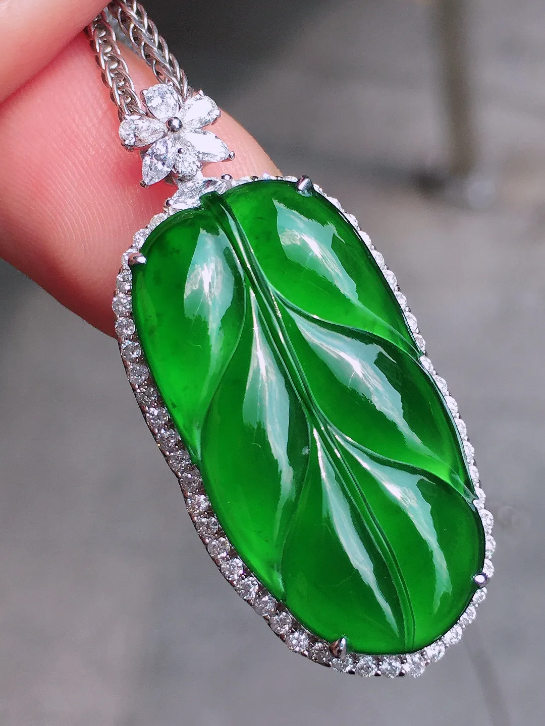 满绿玉叶吊坠，色泽均匀浓郁，玉质细腻，荧光感超
强，饱满圆润，气质满满。18k
金豪华镶嵌
