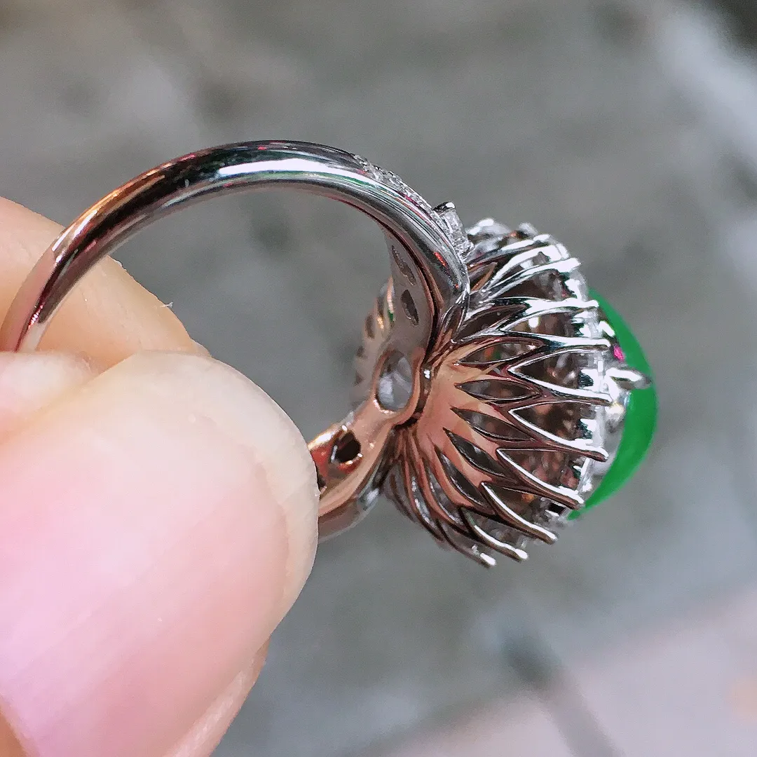 阳绿蛋面戒指，色泽均匀艳丽，玉质细腻，荧光感超
强，饱满圆润，气质满满。18k
金豪华镶嵌
