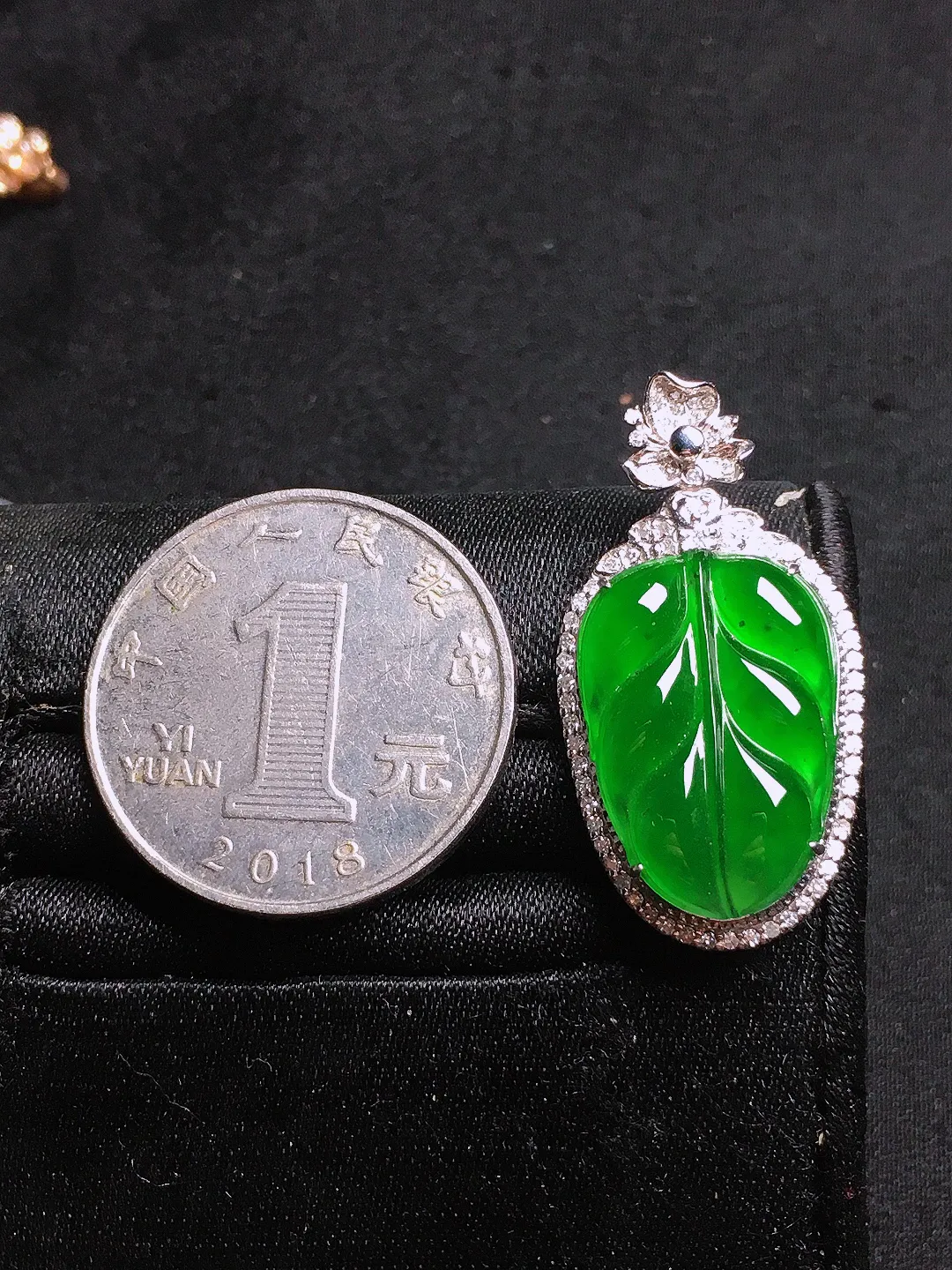满绿玉叶吊坠，色泽均匀浓郁，玉质细腻，荧光感超
强，饱满圆润，气质满满。18k
金豪华镶嵌