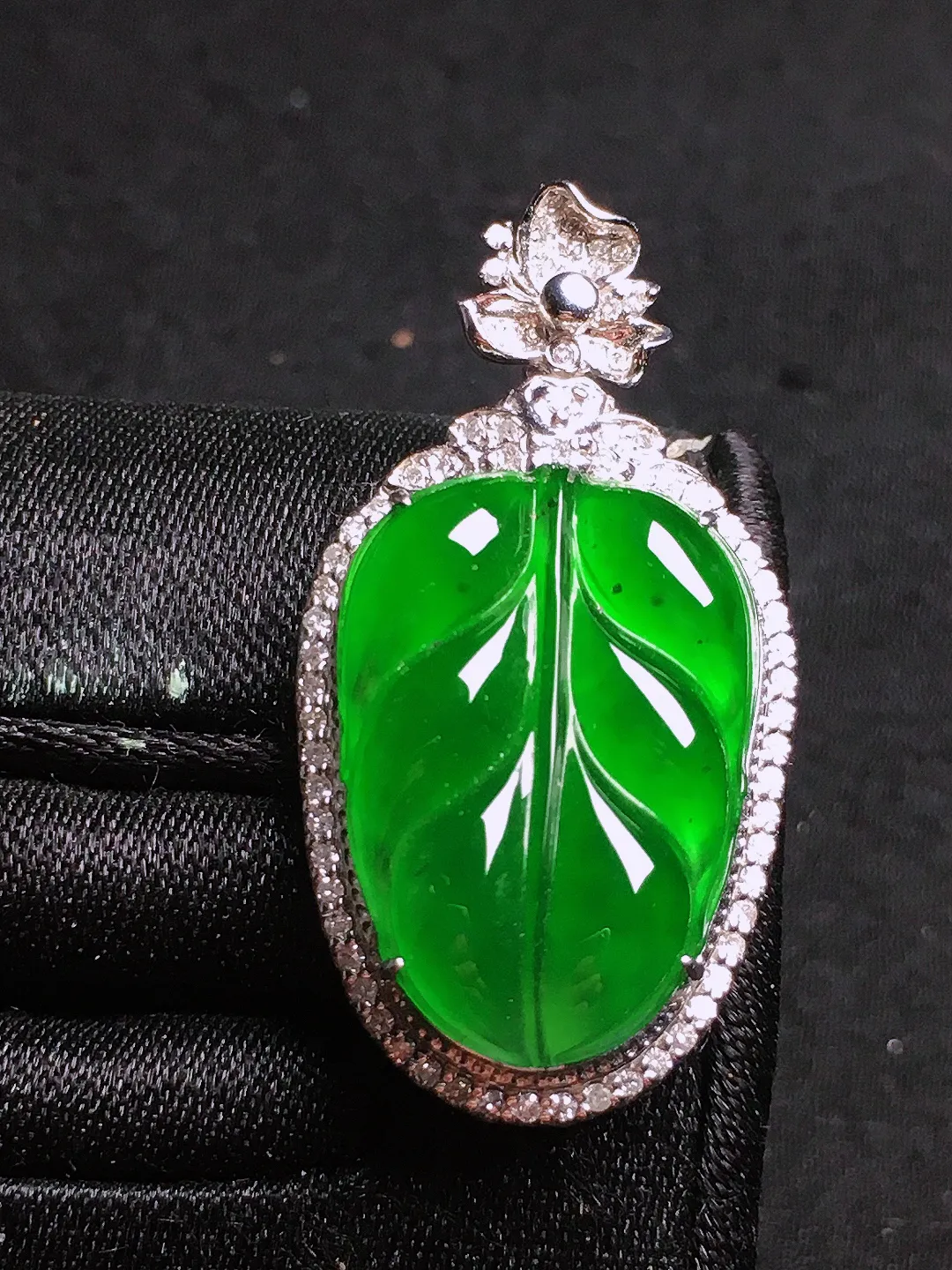 满绿玉叶吊坠，色泽均匀浓郁，玉质细腻，荧光感超
强，饱满圆润，气质满满。18k
金豪华镶嵌