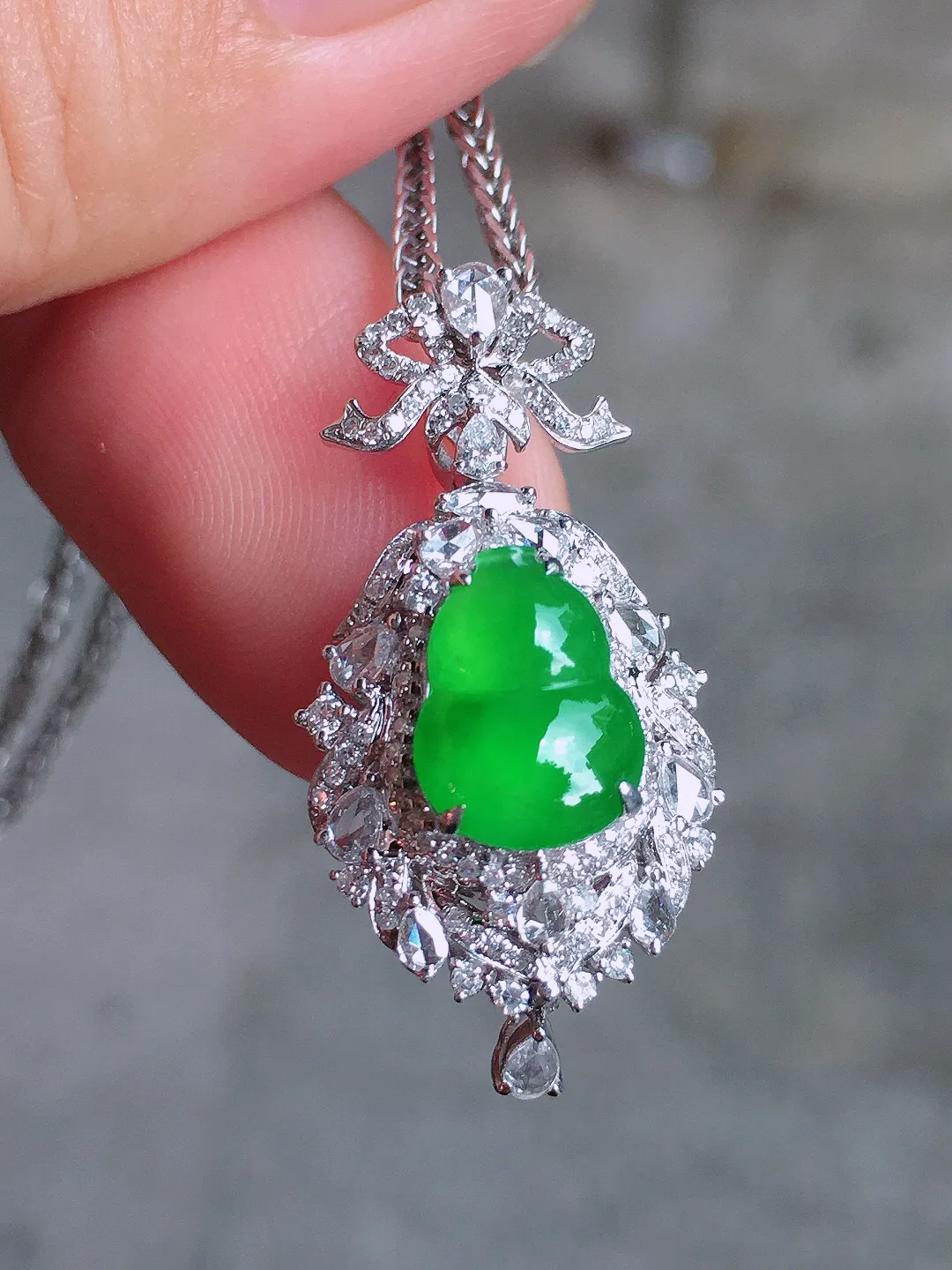 阳绿葫芦吊坠，色泽均匀艳丽，玉质细腻，荧光感超
强，饱满圆润，气质满满。18k
金豪华镶嵌