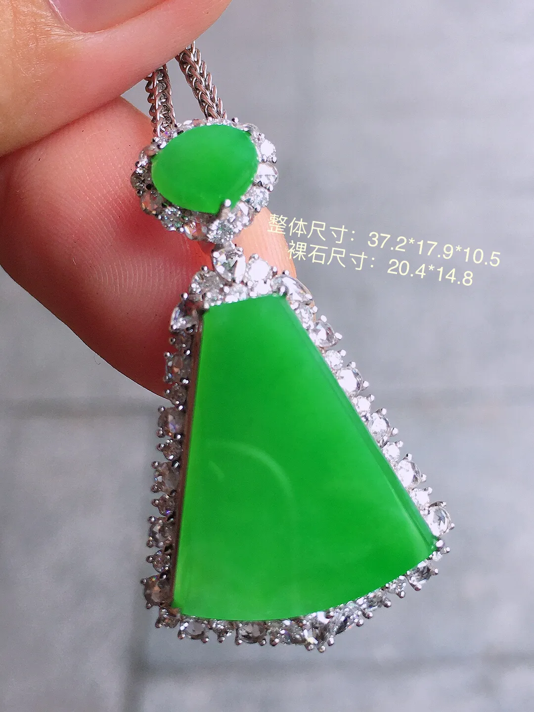 阳绿无事牌吊坠，色泽均匀艳丽，玉质细腻，荧光感超
强，饱满圆润，气质满满。18k
金豪华镶嵌