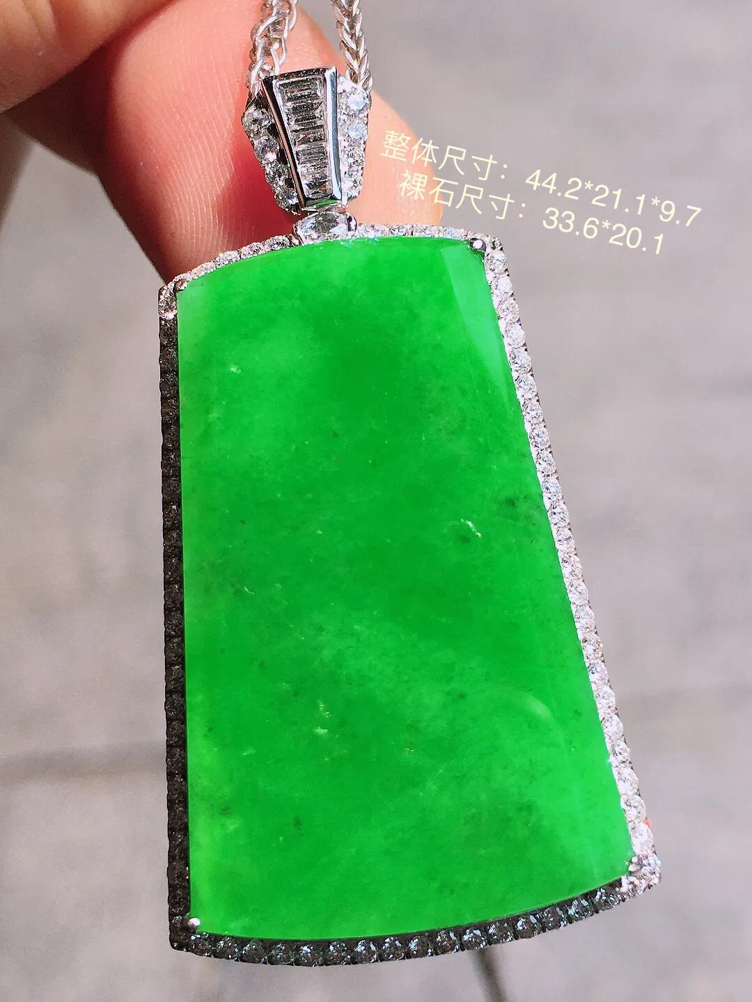 阳绿无事牌吊坠，色泽均匀艳丽，玉质细腻，荧光感超
强，饱满圆润，气质满满。18k
金豪华镶嵌