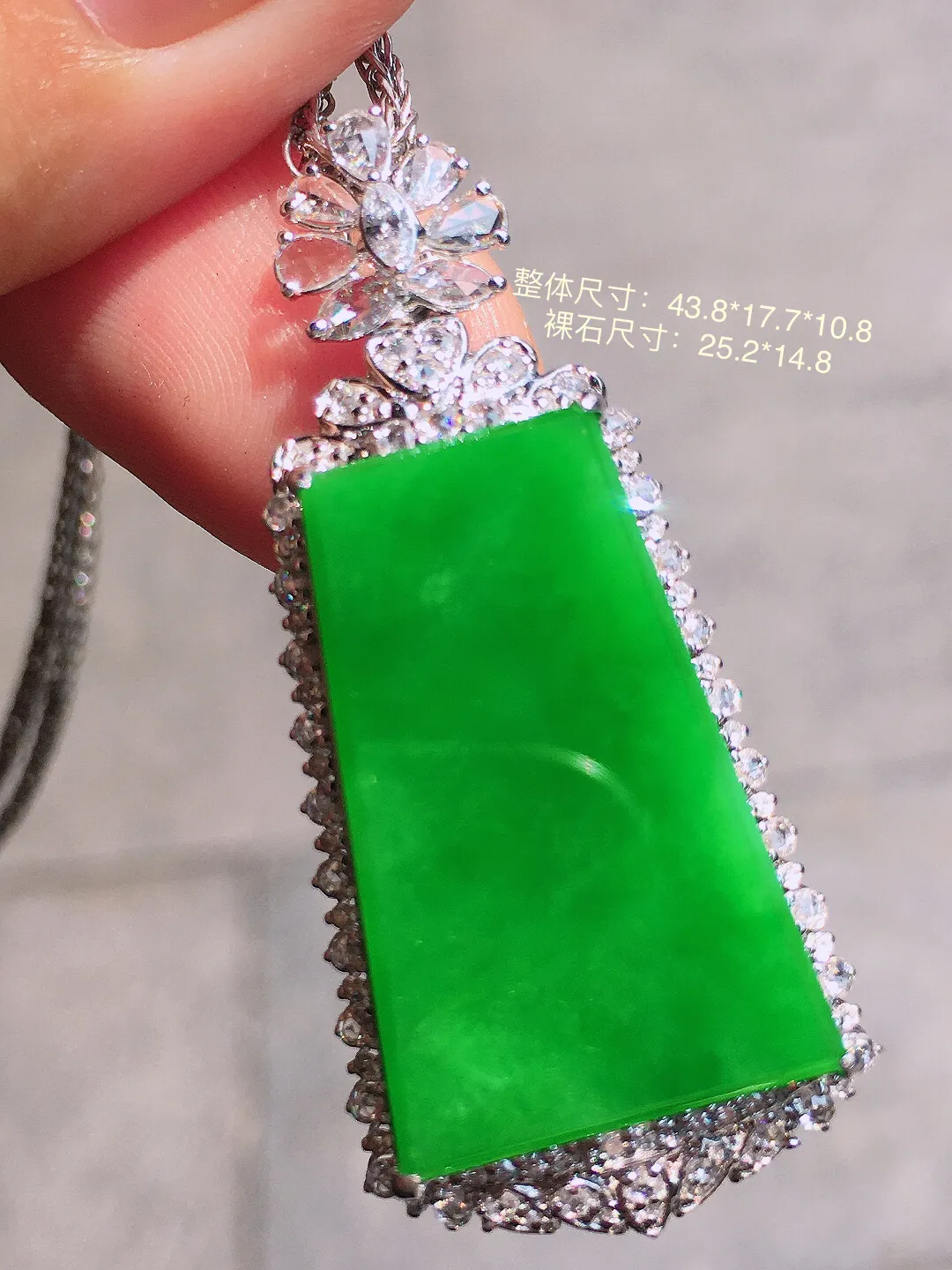 阳绿无事牌吊坠，色泽均匀艳丽，玉质细腻，荧光感超
强，饱满圆润，气质满满。18k
金豪华镶嵌