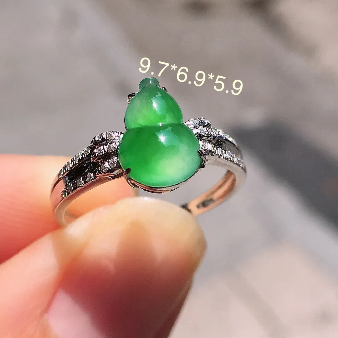 阳绿葫芦戒指，色泽均匀艳丽，玉质细腻，荧光感超
强，饱满圆润，气质满满。18k
金豪华镶嵌