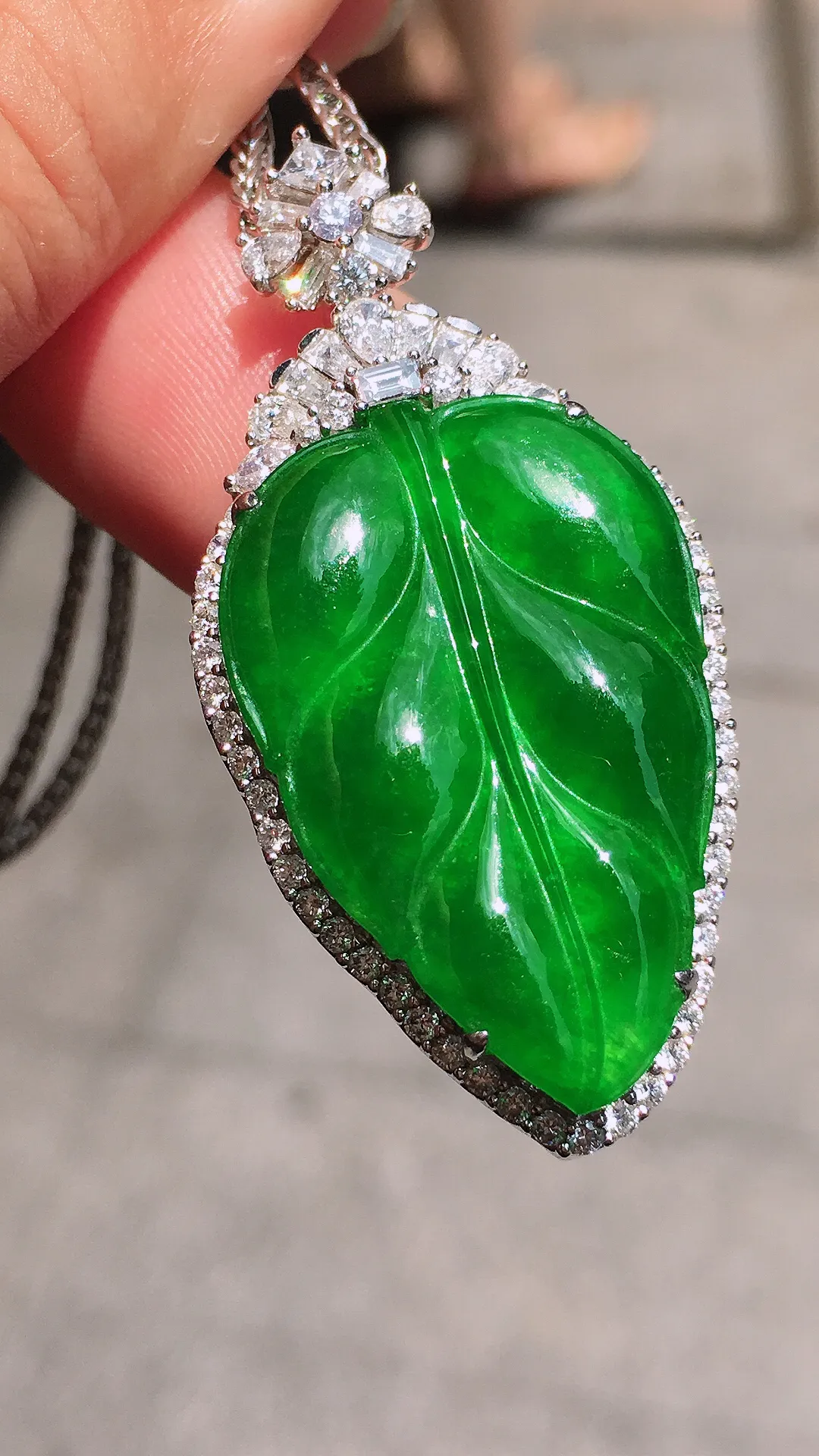阳绿玉叶吊坠，色泽均匀艳丽，玉质细腻，荧光感超
强，饱满圆润，气质满满。18k
金豪华镶嵌