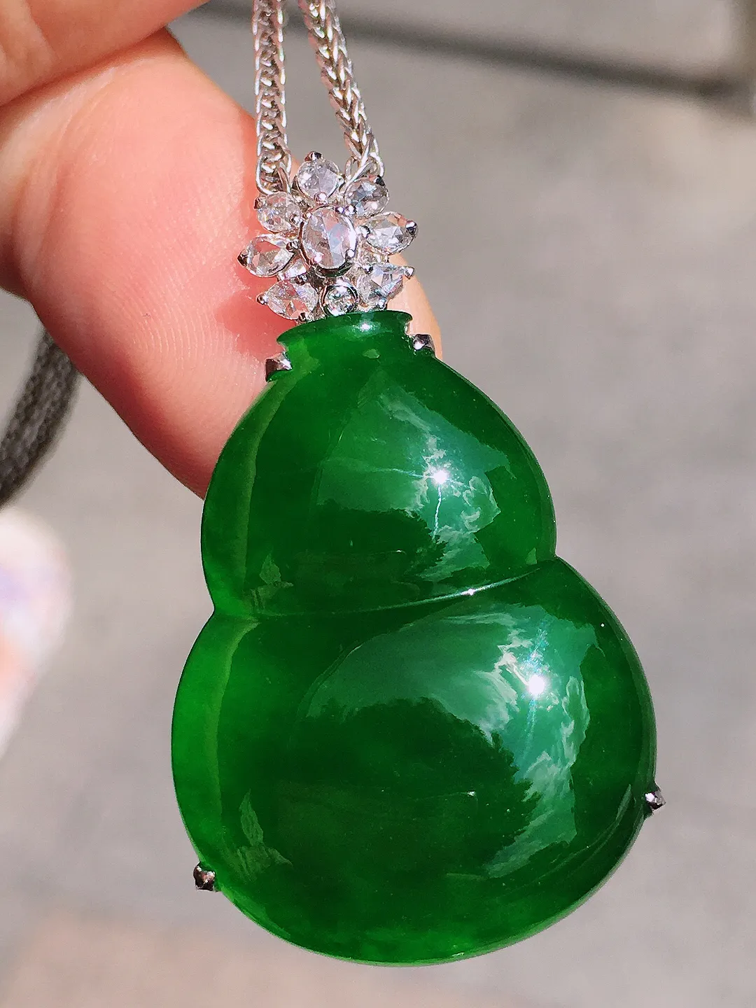 满绿葫芦吊坠，色泽均匀浓郁，玉质细腻，荧光感超
强，饱满圆润，气质满满。18k
金豪华镶嵌