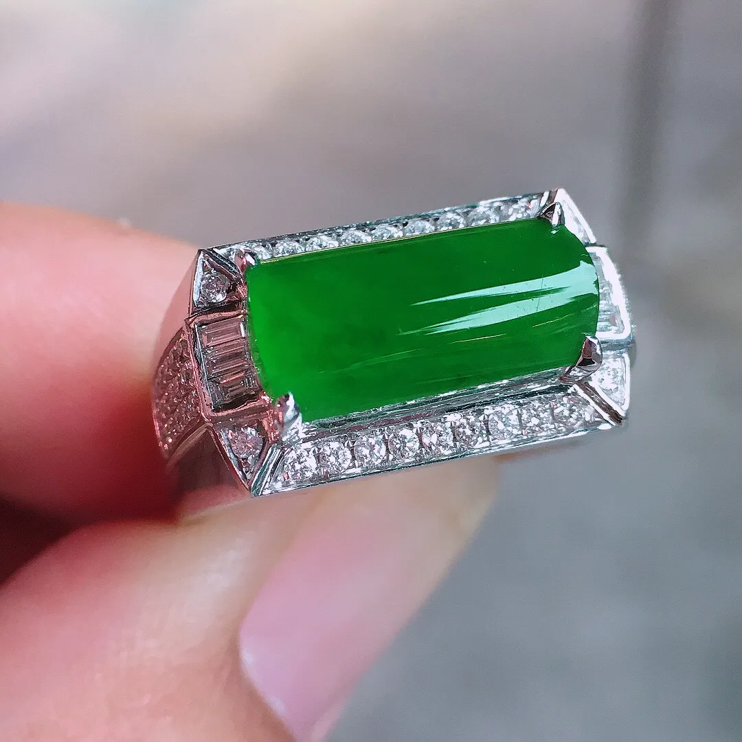 阳绿马鞍戒指，色泽均匀艳丽，玉质细腻，荧光感超
强，饱满圆润，气质满满。18k
金豪华镶嵌
