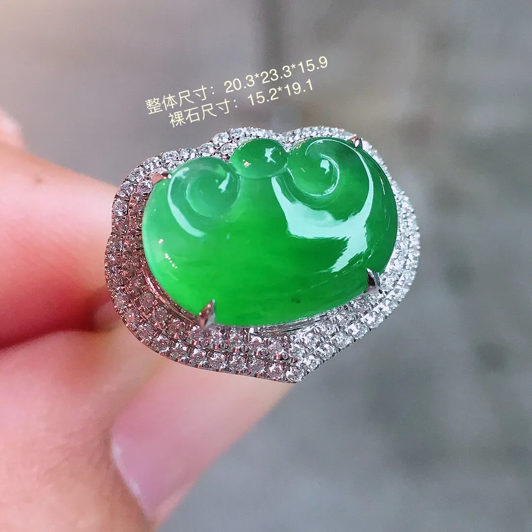阳绿如意戒指，色泽均匀艳丽，玉质细腻，荧光感超
强，饱满圆润，气质满满。18k
金豪华镶嵌