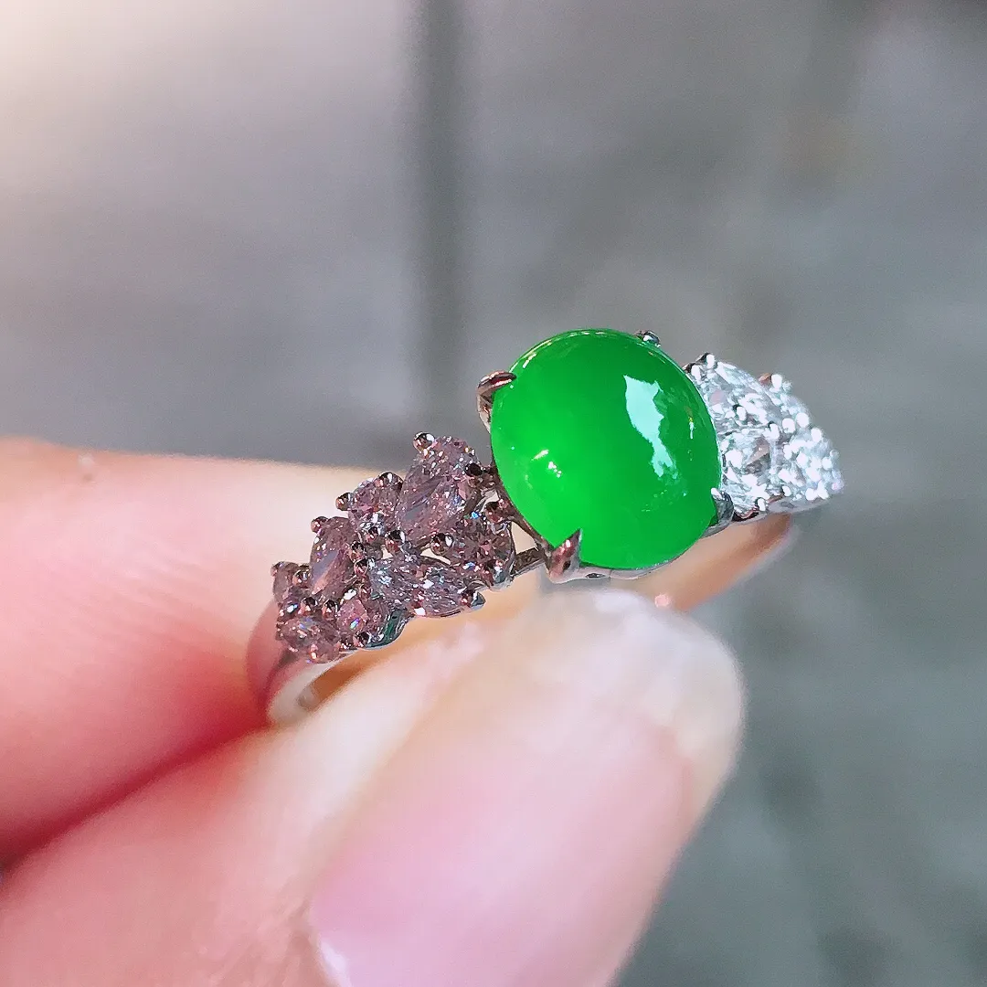 阳绿蛋面戒指，色泽均匀艳丽，玉质细腻，荧光感超
强，饱满圆润，气质满满。18k
金豪华镶嵌