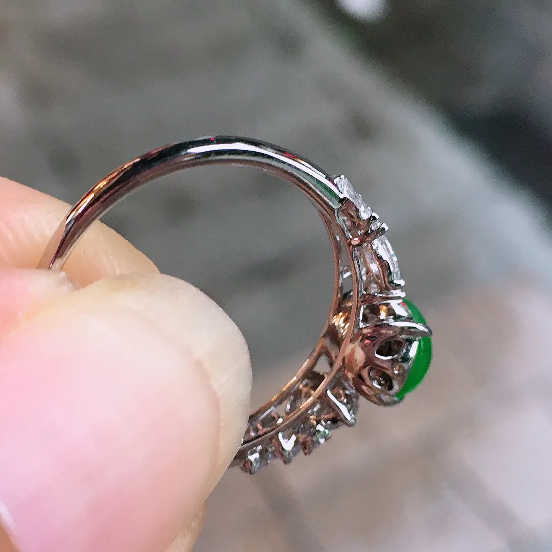 阳绿蛋面戒指，色泽均匀艳丽，玉质细腻，荧光感超
强，饱满圆润，气质满满。18k
金豪华镶嵌