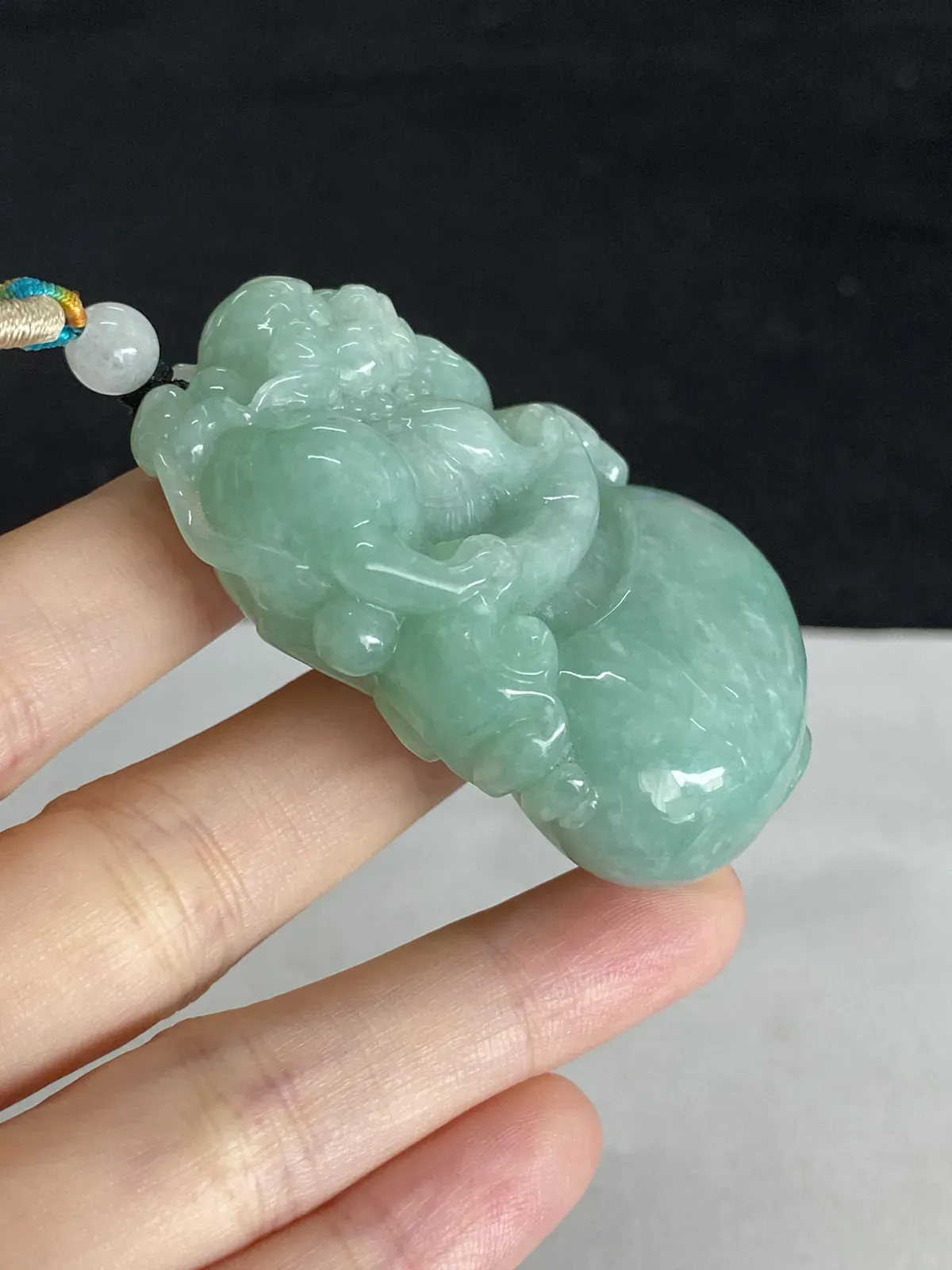 翡翠糯化种淡绿色吊坠，配珠未测