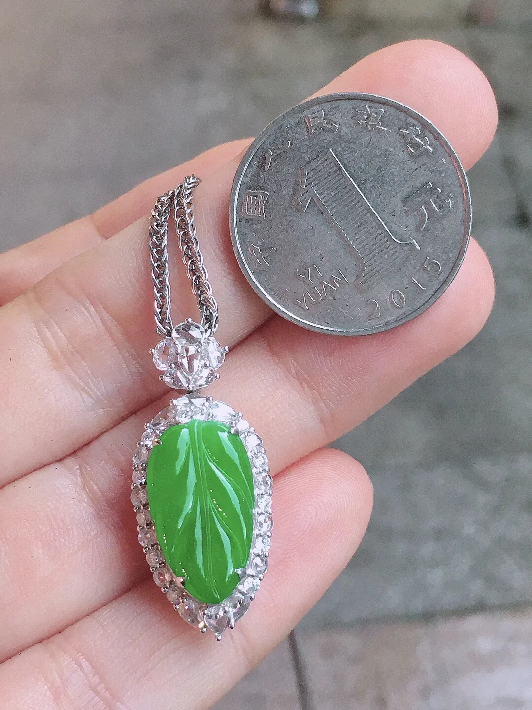 阳绿玉叶吊坠，色泽均匀艳丽，玉质细腻，荧光感超
强，饱满圆润，气质满满。18k
金豪华镶嵌