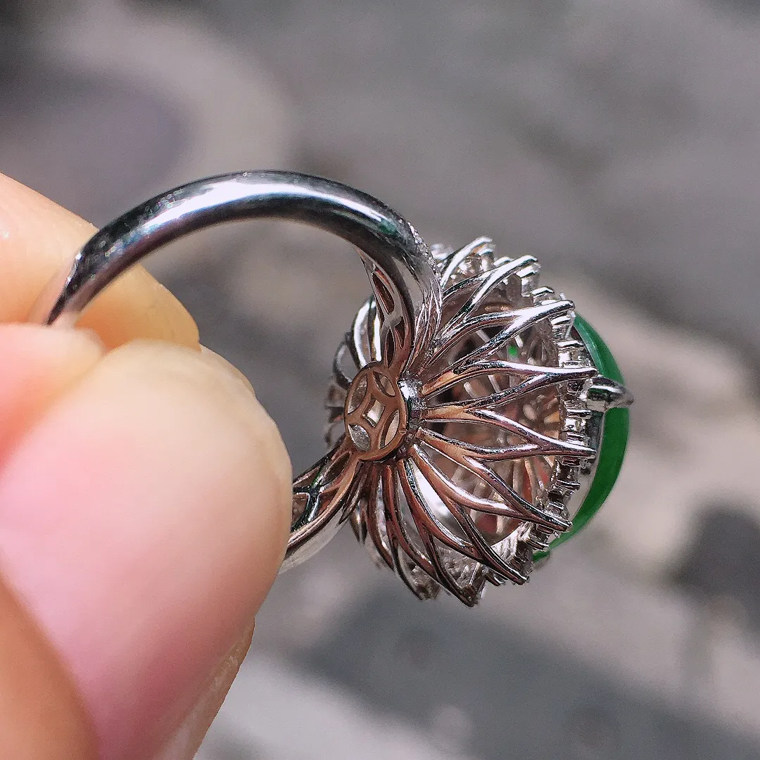 阳绿蛋面戒指，色泽均匀艳丽，玉质细腻，荧光感超
强，饱满圆润，气质满满。18k
金豪华镶嵌