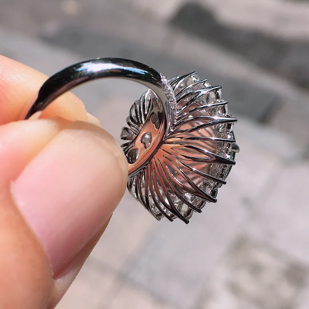阳绿蛋面戒指，色泽均匀艳丽，玉质细腻，荧光感超
强，饱满圆润，气质满满。18k
金豪华镶嵌