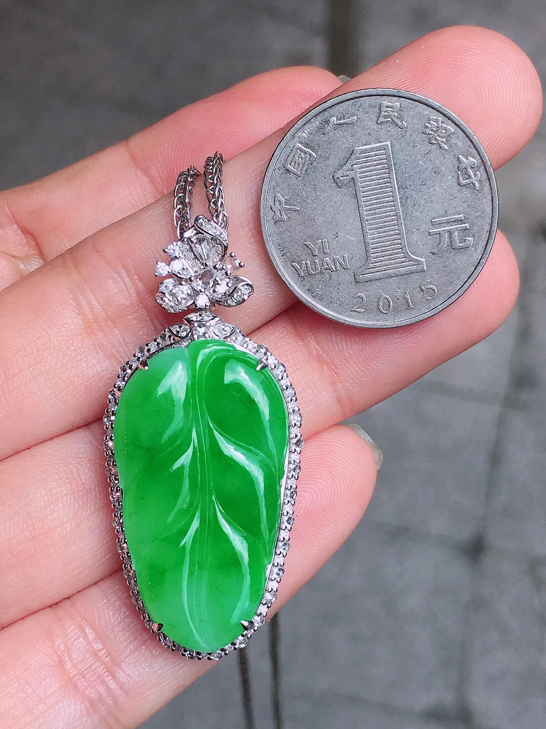 阳绿玉叶吊坠，色泽均匀艳丽，玉质细腻，荧光感超
强，饱满圆润，气质满满。18k
金豪华镶嵌