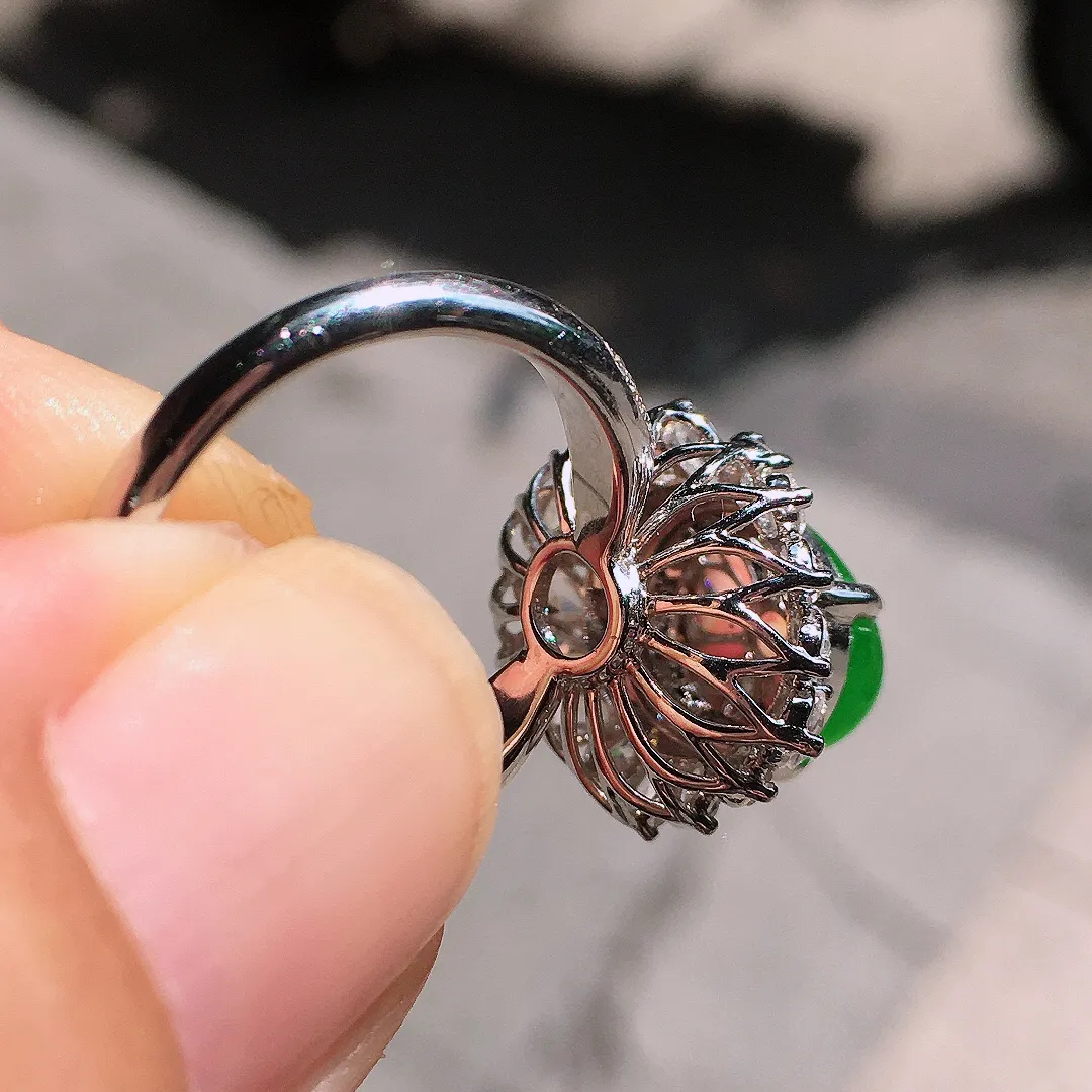 阳绿蛋面戒指，色泽均匀艳丽，玉质细腻，荧光感超
强，饱满圆润，气质满满。18k
金豪华镶嵌