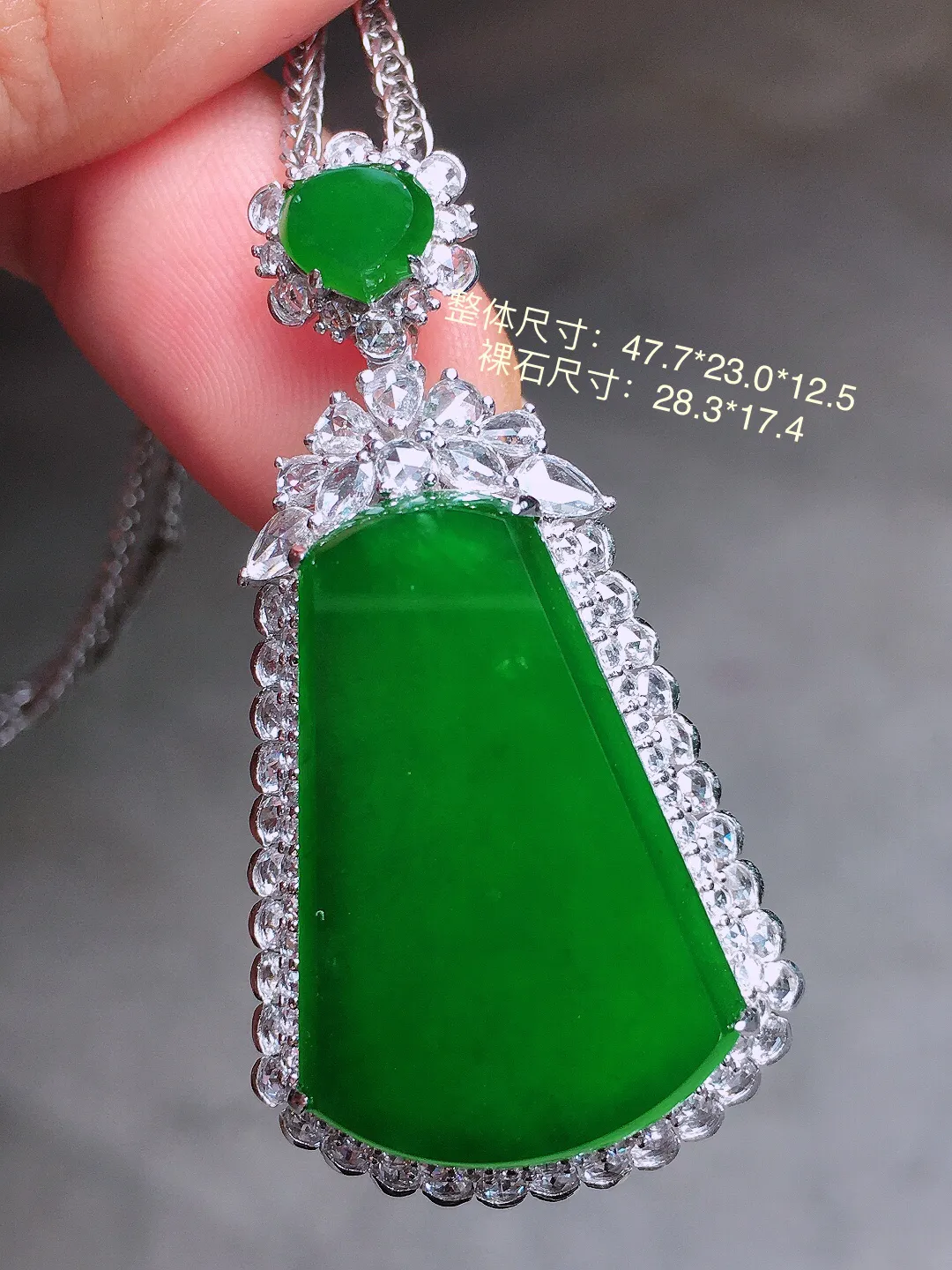 辣绿无事牌吊坠，色泽均匀艳丽，玉质细腻，荧光感超
强，饱满圆润，气质满满。18k
金豪华镶嵌