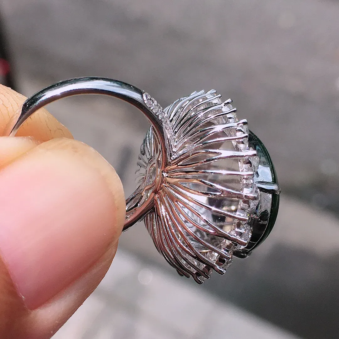 阳绿蛋面戒指，色泽均匀艳丽，玉质细腻，荧光感超
强，饱满圆润，气质满满。18k
金豪华镶嵌