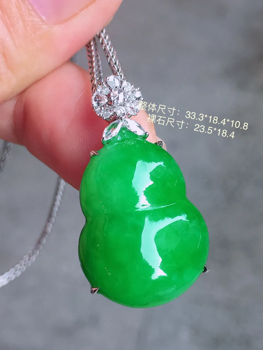 阳绿葫芦吊坠，色泽均匀艳丽，玉质细腻，荧光感超
强，饱满圆润，气质满满。18k
金豪华镶嵌