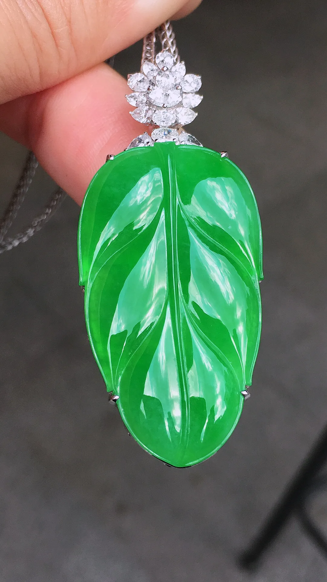 阳绿玉叶吊坠，色泽均匀艳丽，玉质细腻，荧光感超
强，饱满圆润，简单大气，18k
金豪华镶嵌