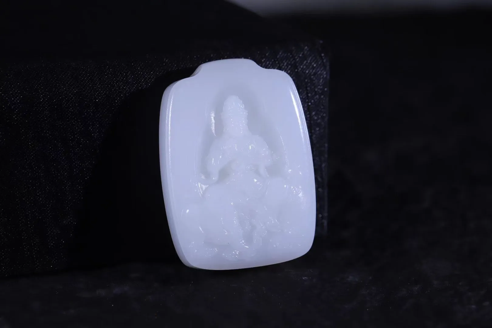 典藏
【普贤白象载道】收藏级羊脂白玉牌，玉脂浑厚如凝膏，细度过灯无瑕，白润似雪映晨光。浮雕普贤菩萨垂目静坐白象背，象身俯卧如承须弥之重，衣袂流转间刀工藏禅机。玉质润泽透心，寓智慧行愿，乃传世白玉之魄，典藏间尽显东方灵韵。
【规格】50-36-12mm，46.3g