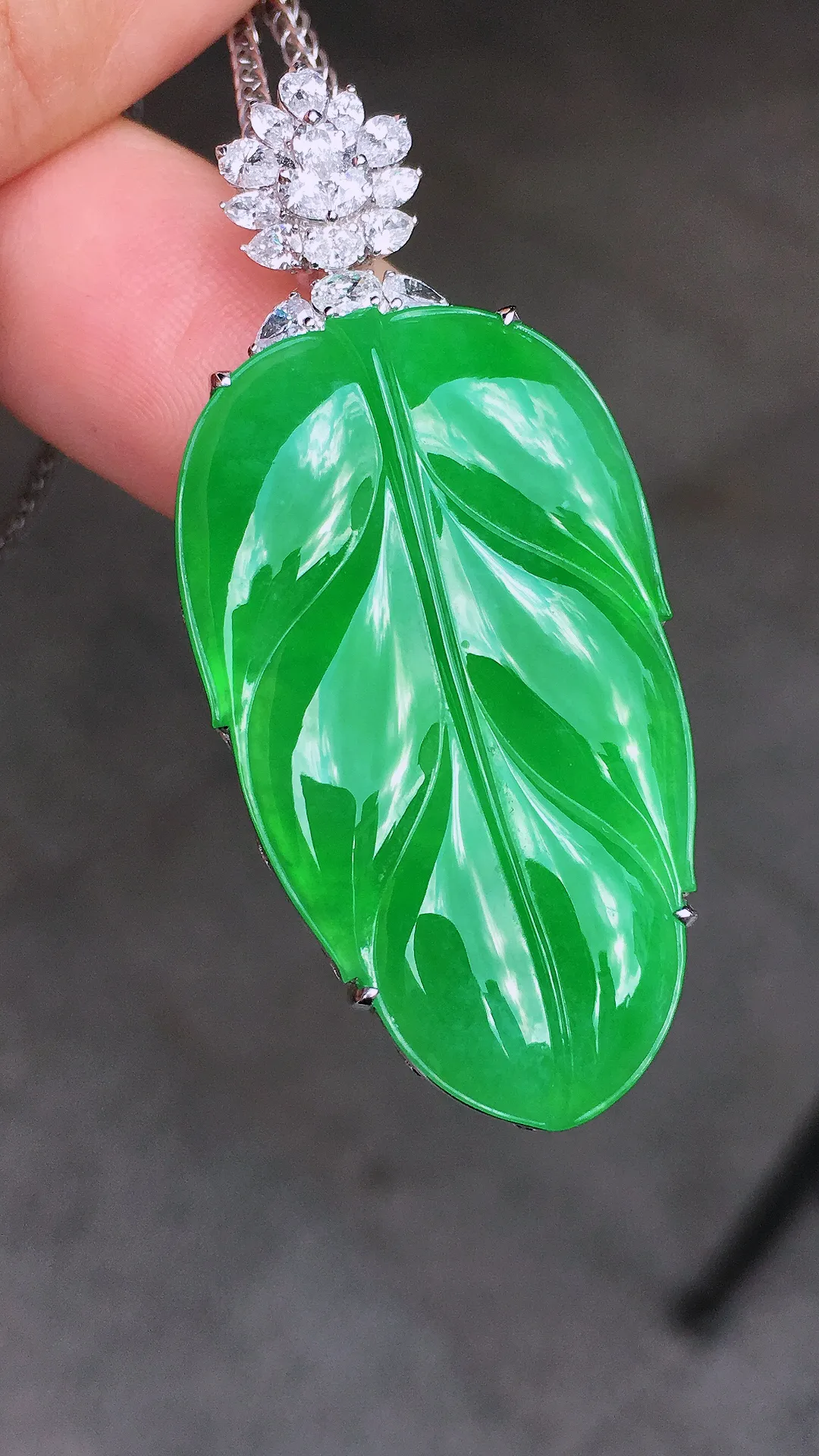阳绿玉叶吊坠，色泽均匀艳丽，玉质细腻，荧光感超
强，饱满圆润，简单大气，18k
金豪华镶嵌