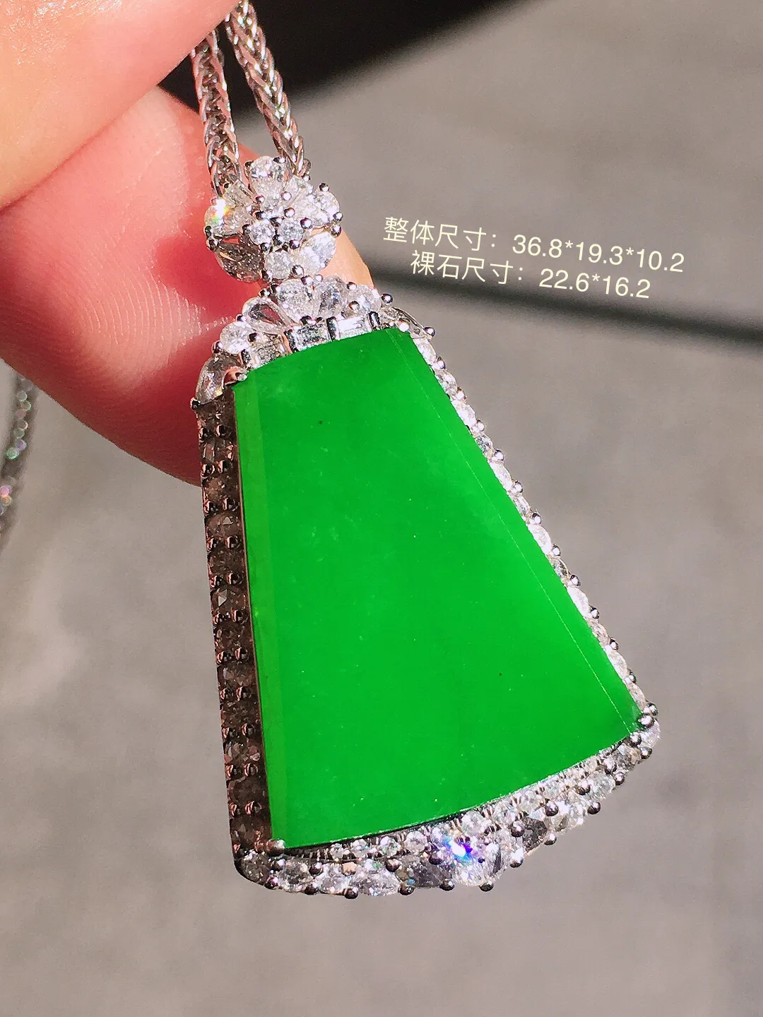 阳绿无事牌吊坠，色泽均匀艳丽，玉质细腻，荧光感超
强，饱满圆润，尽显优雅气质，18k
金豪华镶嵌