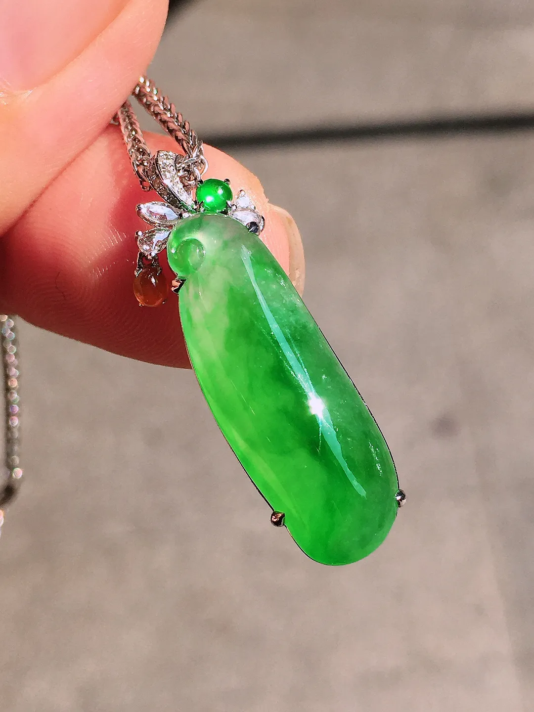 阳绿福瓜吊坠，色泽均匀艳丽，玉质细腻，荧光感超
强，饱满圆润，尽显优雅气质，18k
金豪华镶嵌