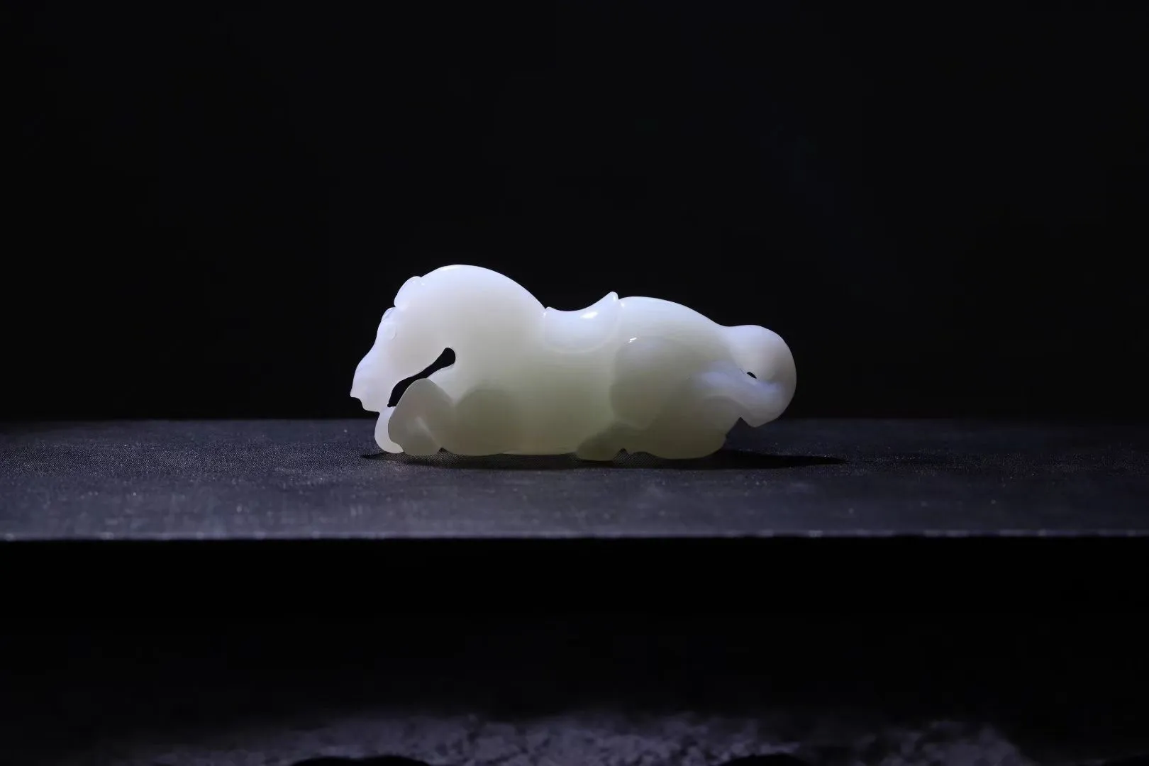 祥瑞臻品
【马~丰年载福】和田羊脂白玉精雕瑞马，玉质凝若羊脂膏腴，透光处泛起蜜蜡般柔晕。马身圆润如满月悬空，丰腴而不失矫健，鬃尾卷曲似祥云凝脂，四蹄敦实若莲台承露。肌骨线条浑圆流转，腹部饱满暗合聚财之相，回首凝眸时玉光温润生暖意，既可陈于案头作五谷丰登之景，亦能盈握掌心触福泽流转。
【规格】61-21-26mm,38.6g