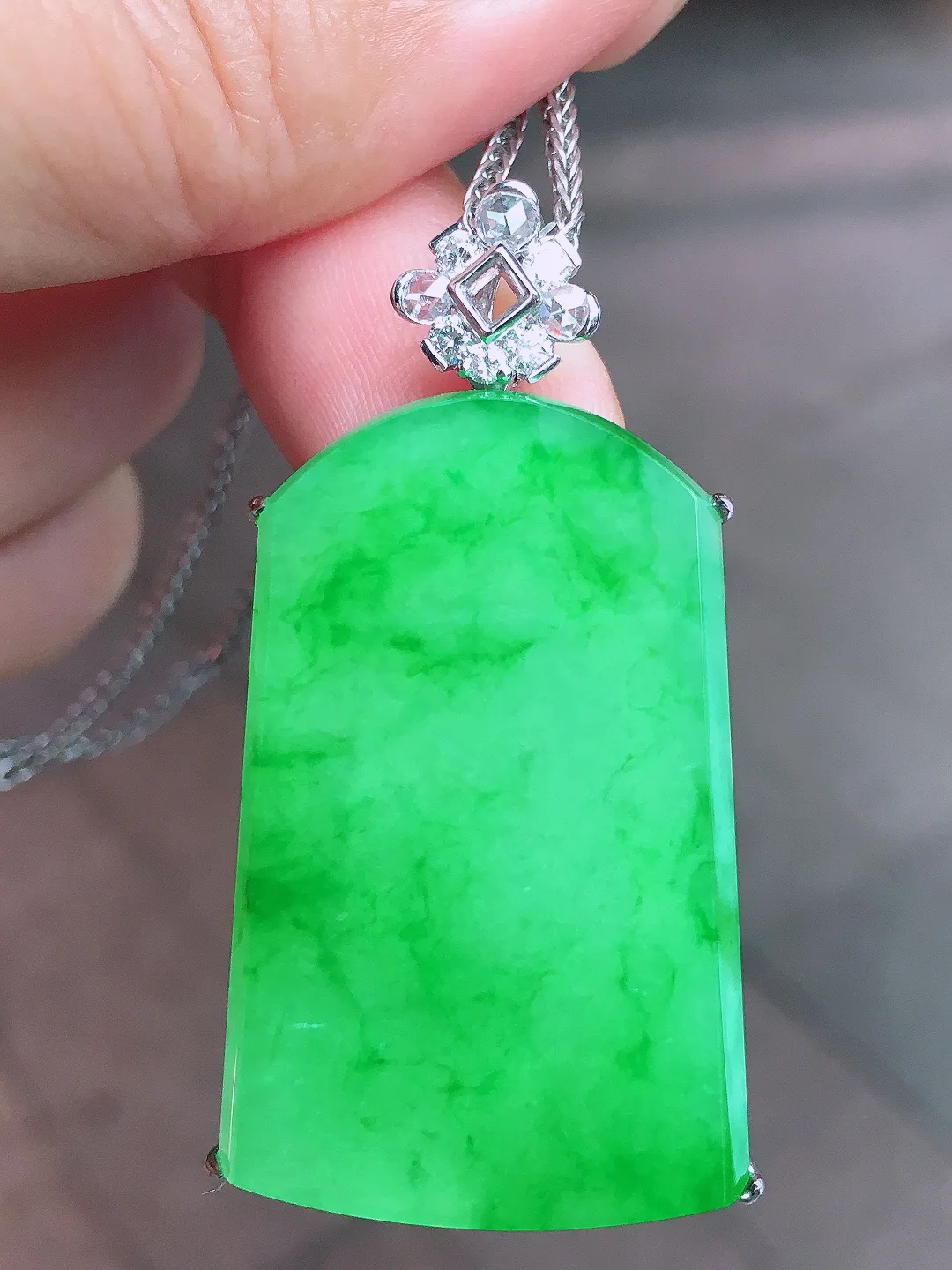 阳绿无事牌吊坠，色泽均匀艳丽，玉质细腻，荧光感超
强，饱满圆润，尽显优雅气质，18k
金豪华镶嵌